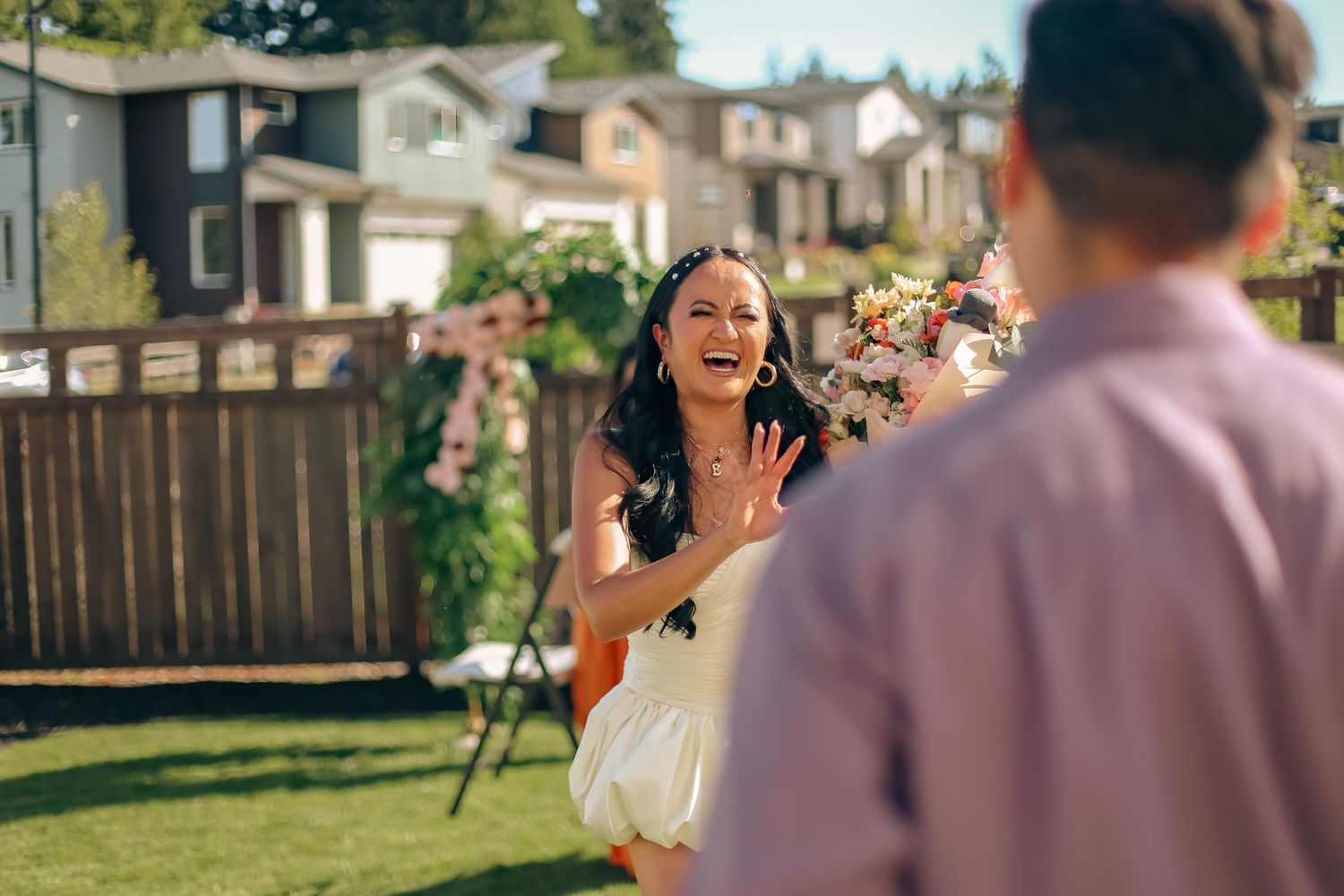 A woman in a white bridal dress surprised by her fiancé