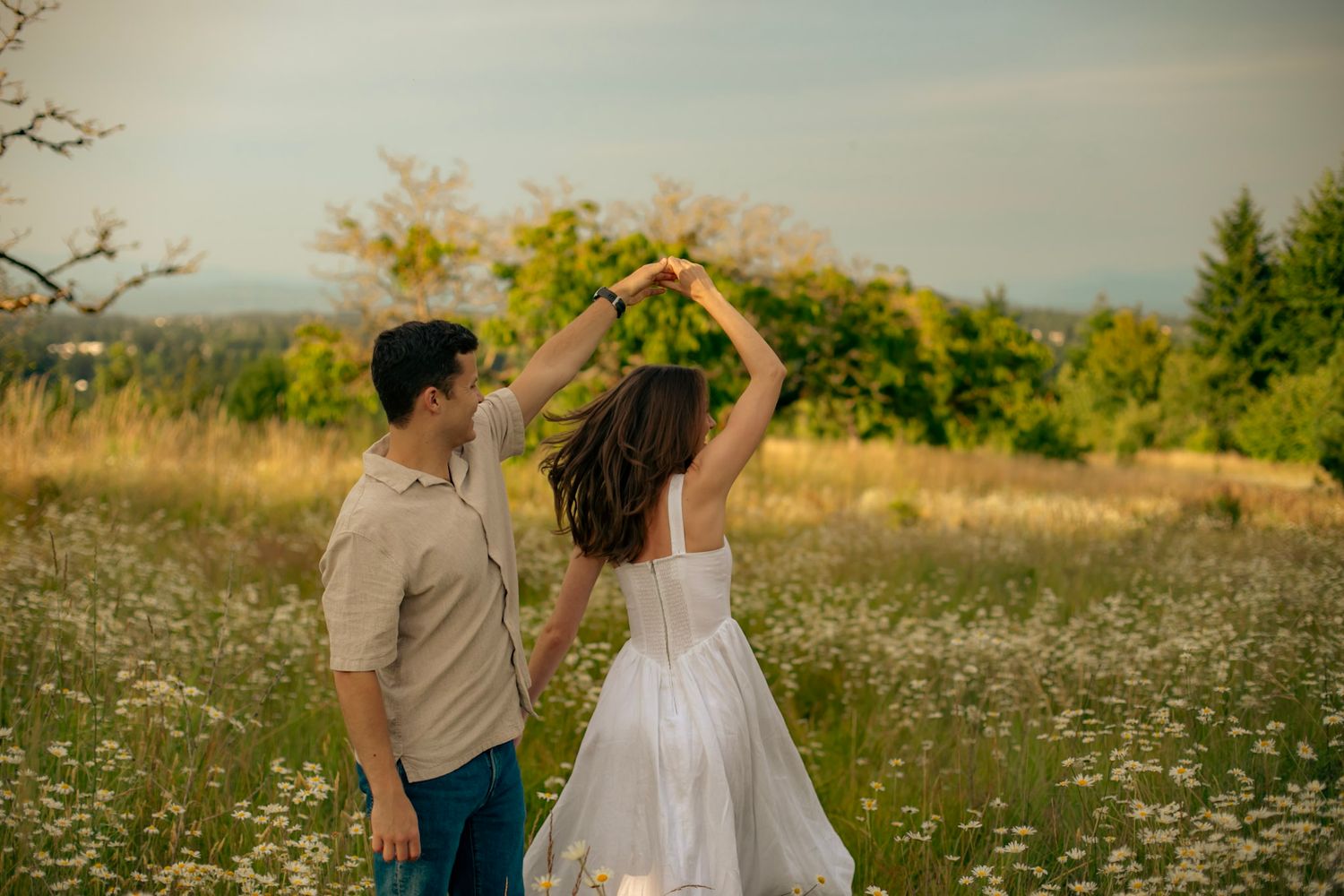 A man twirls his partner in a field of wildflowers