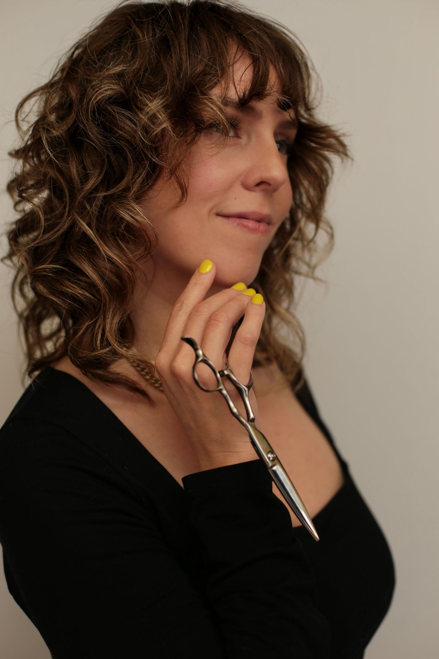 Woman holding hair cutting scissors for hair styling branding shoot