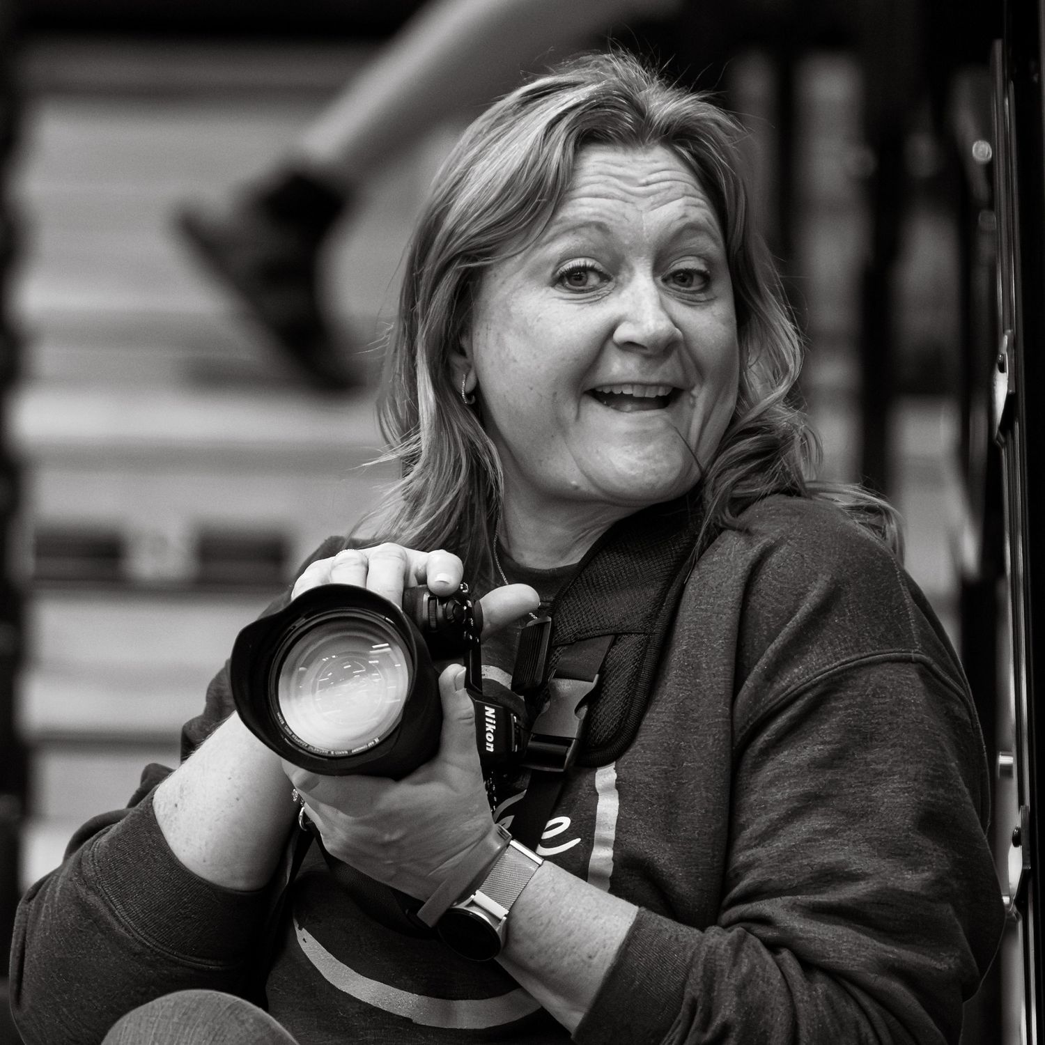 Black and white portrait of a Sarah Hanke, co owner of Hanke Studios, holding a professional camera.