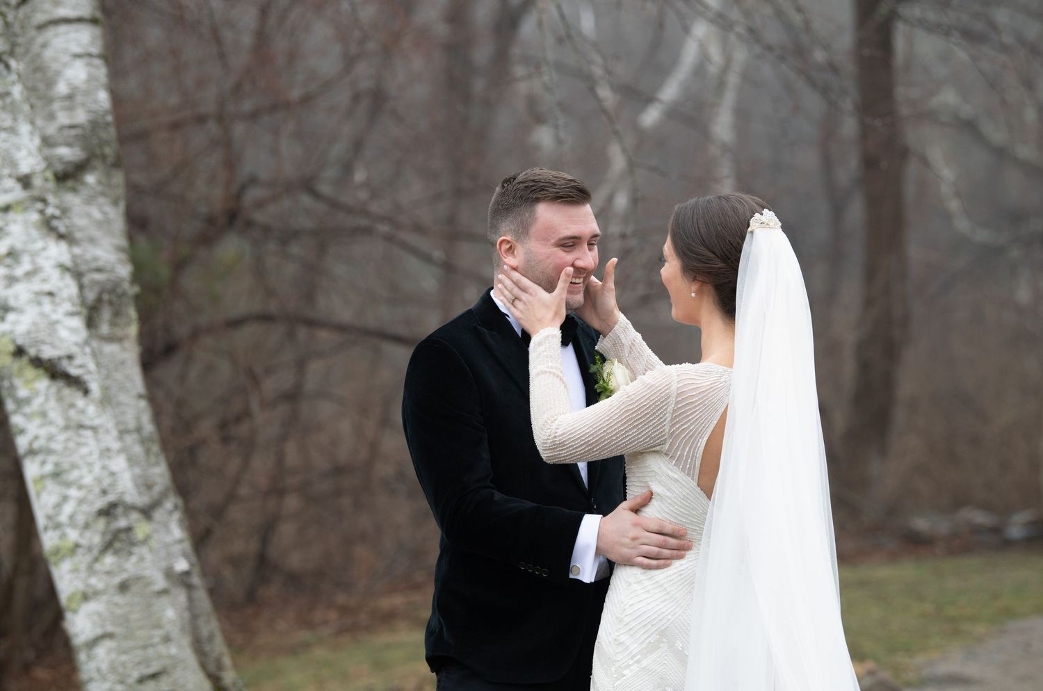 A bride and groom share an intimate moment outdoors in winter during their wedding photo session.