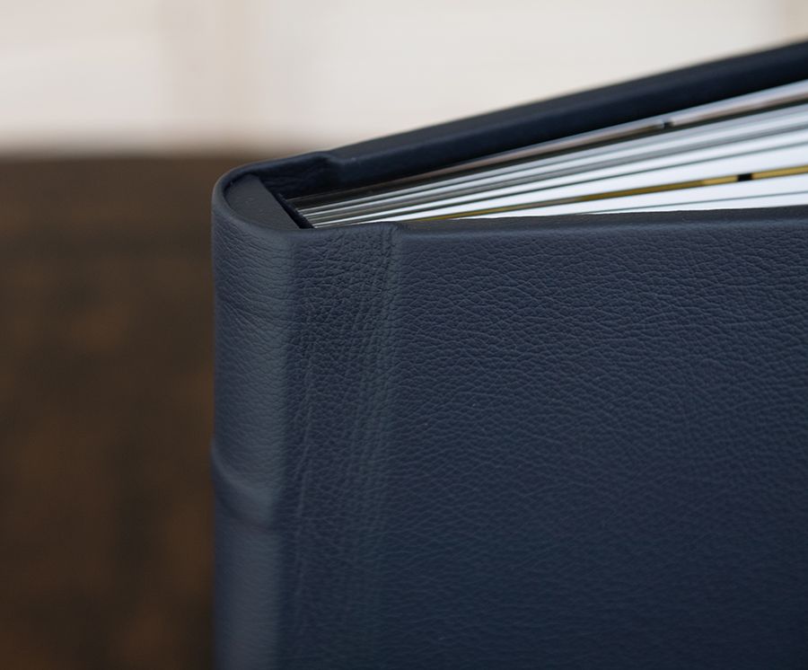 Close-up view of black leather book spines arranged in a row showing texture and binding details.