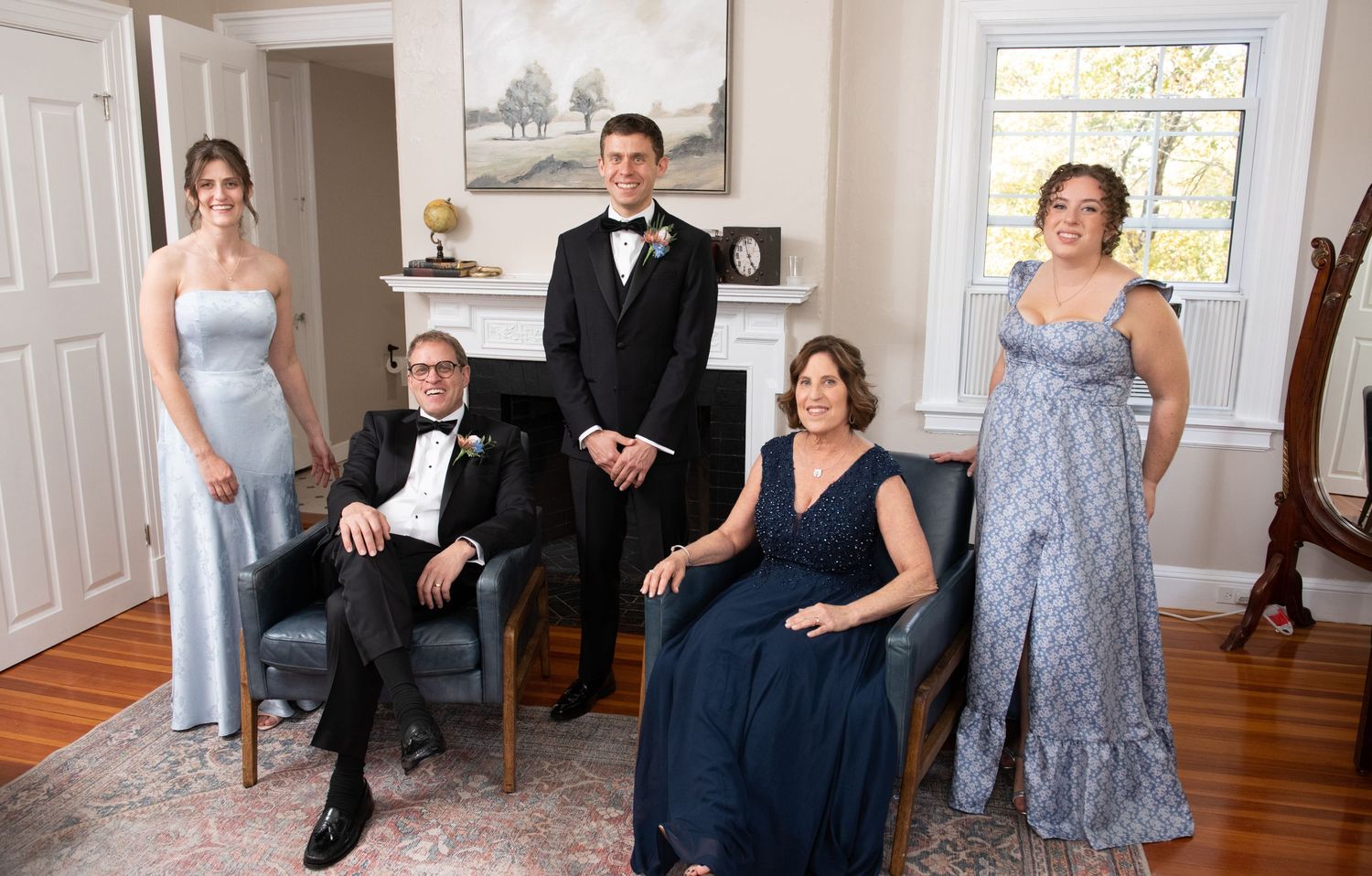 Wedding party members in formal attire pose together in an elegant indoor setting.