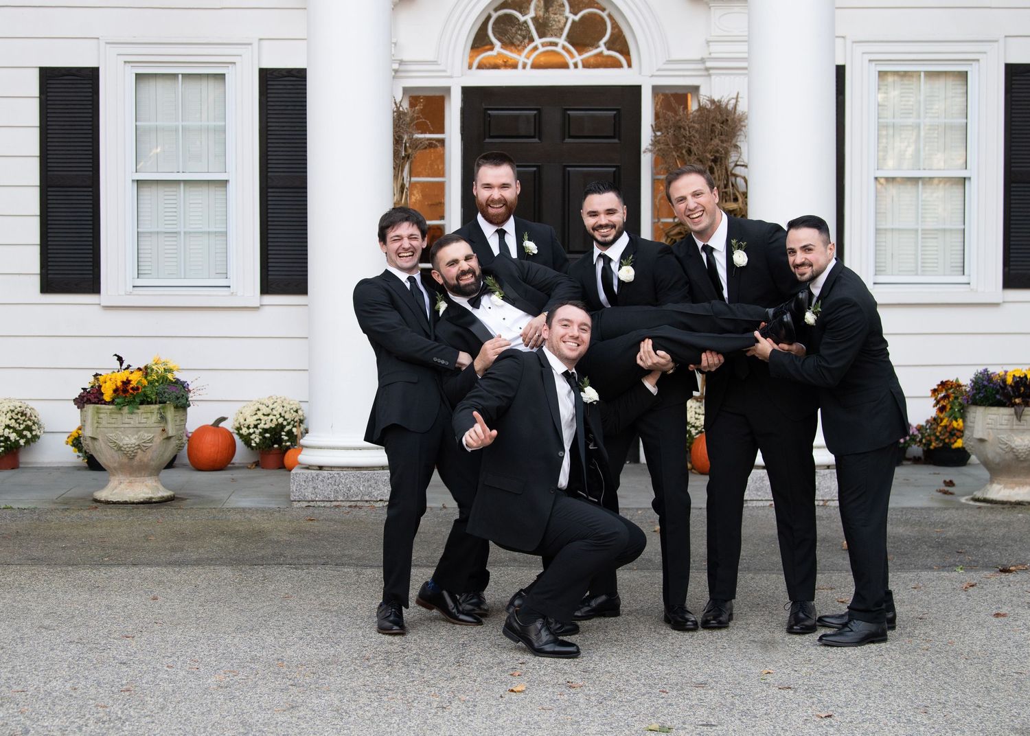 Wedding party members in formal attire pose playfully in sequence of connected photos outside white building.