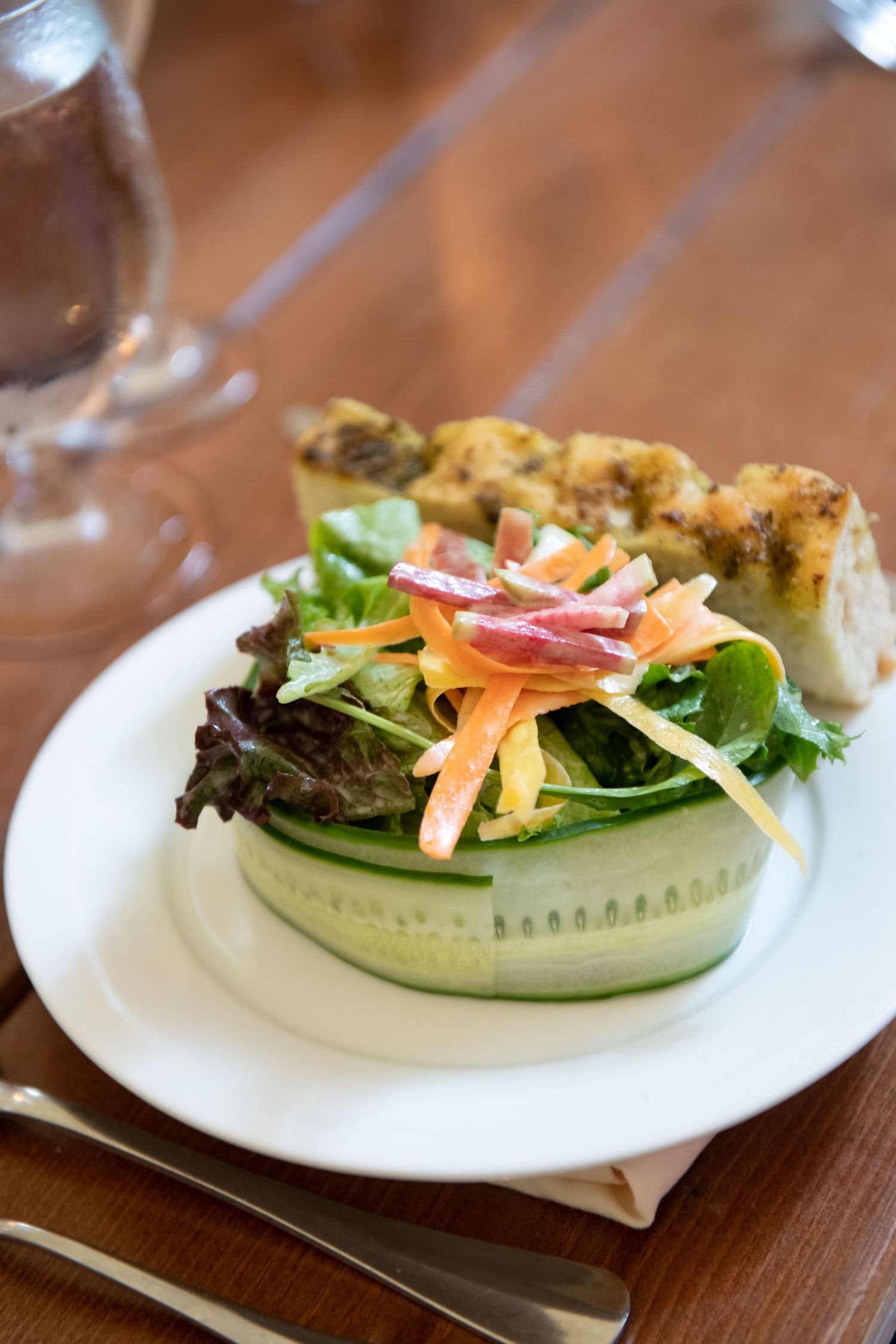 Fresh garden salad served on white plates with colorful vegetables and garnish.