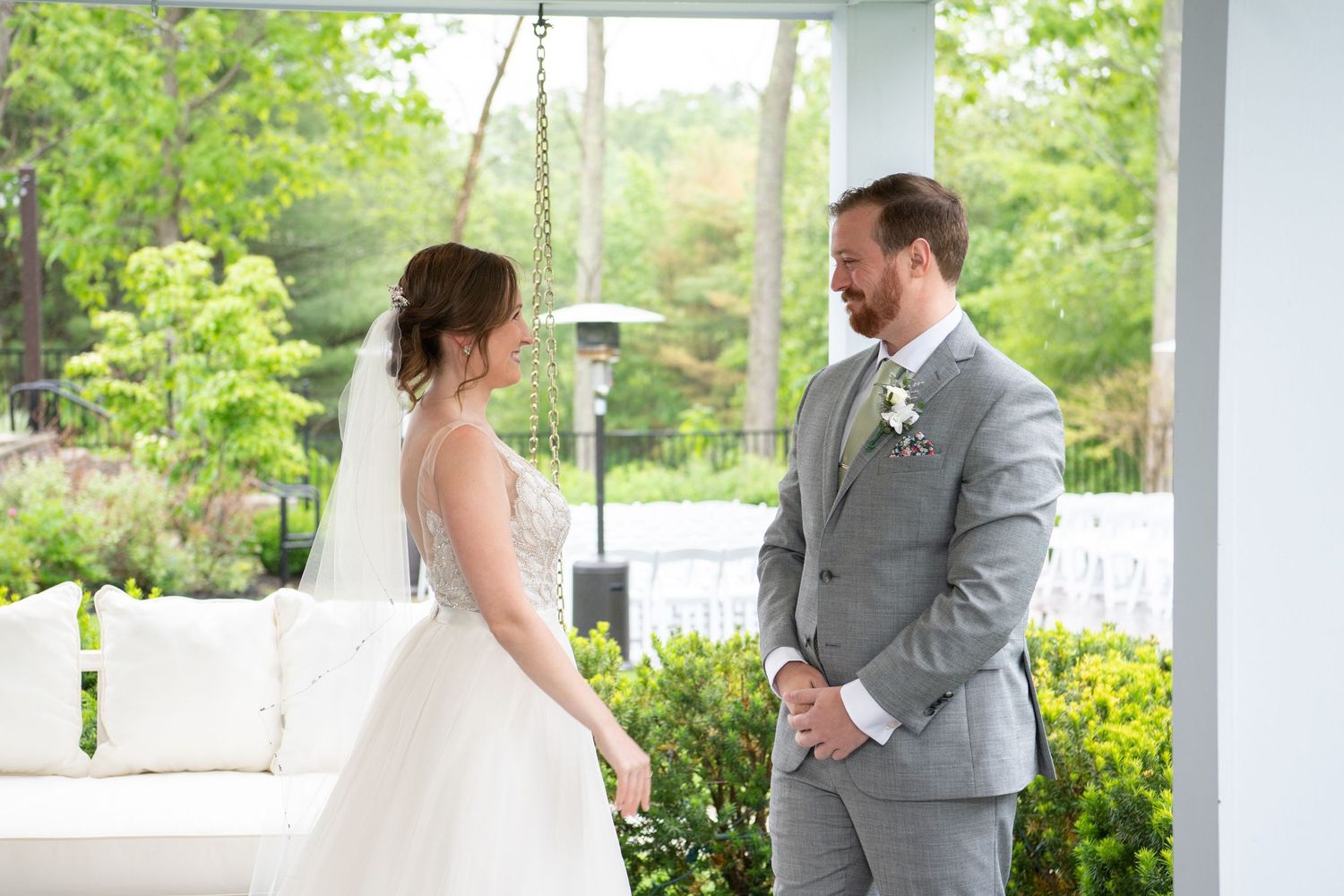 A romantic first look moment between newlyweds in an outdoor garden setting with lush greenery.