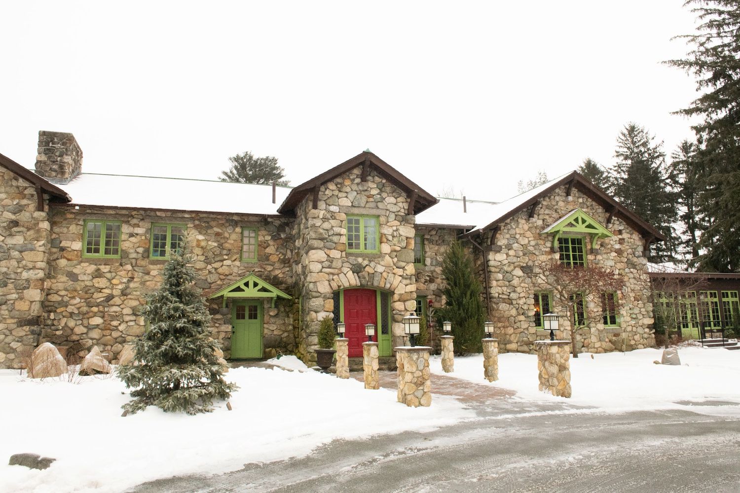 A panoramic view of rustic stone buildings covered in snow during winter at a historic property.
