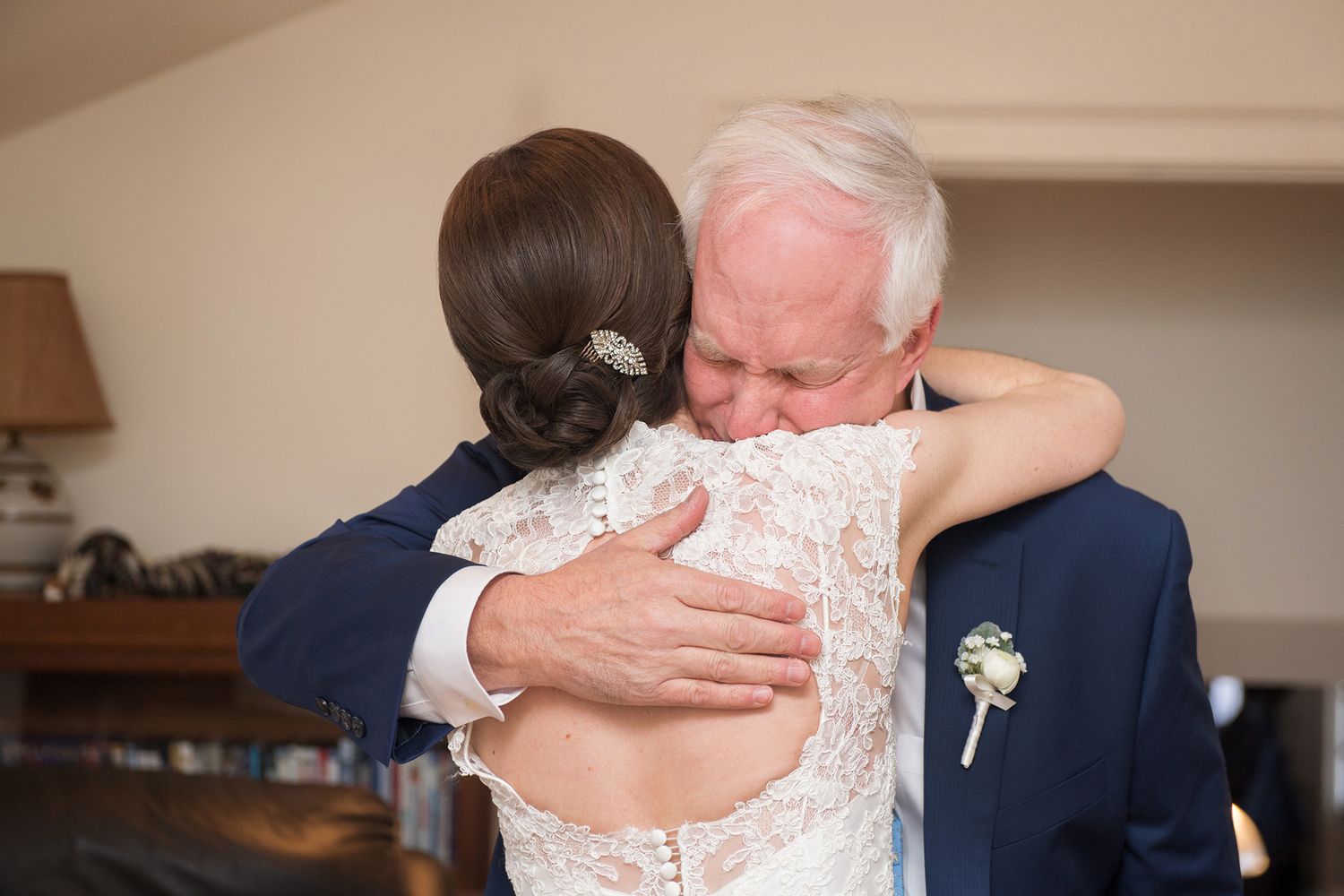 A tender embrace and kiss shared between a couple in formal wedding attire during their special celebration.