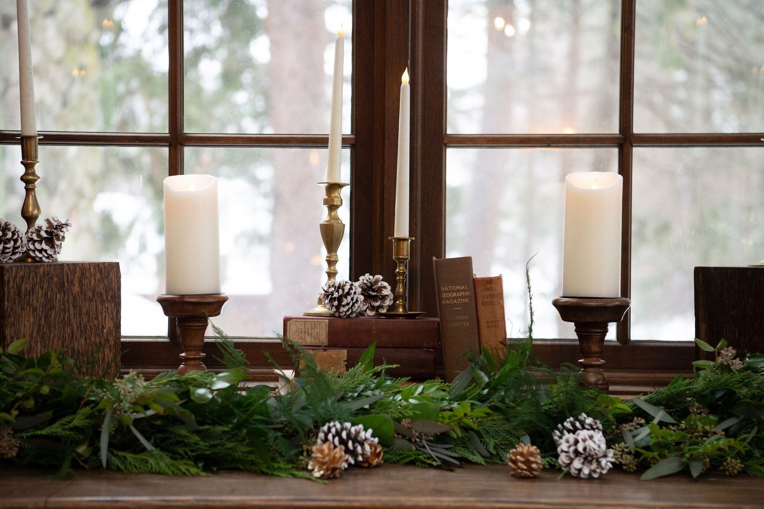 A rustic wooden window sill decorated with pine cones and natural elements in a cozy cabin setting.