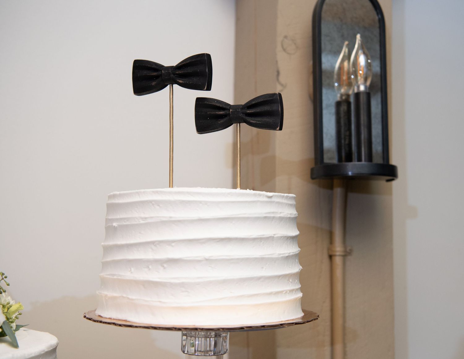 White paper lantern pendant light with black bow accent hangs from ceiling in modern interior space.