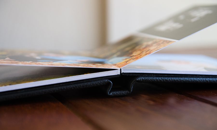Close-up view of an open book with blurred pages and a dark binding against a white background.