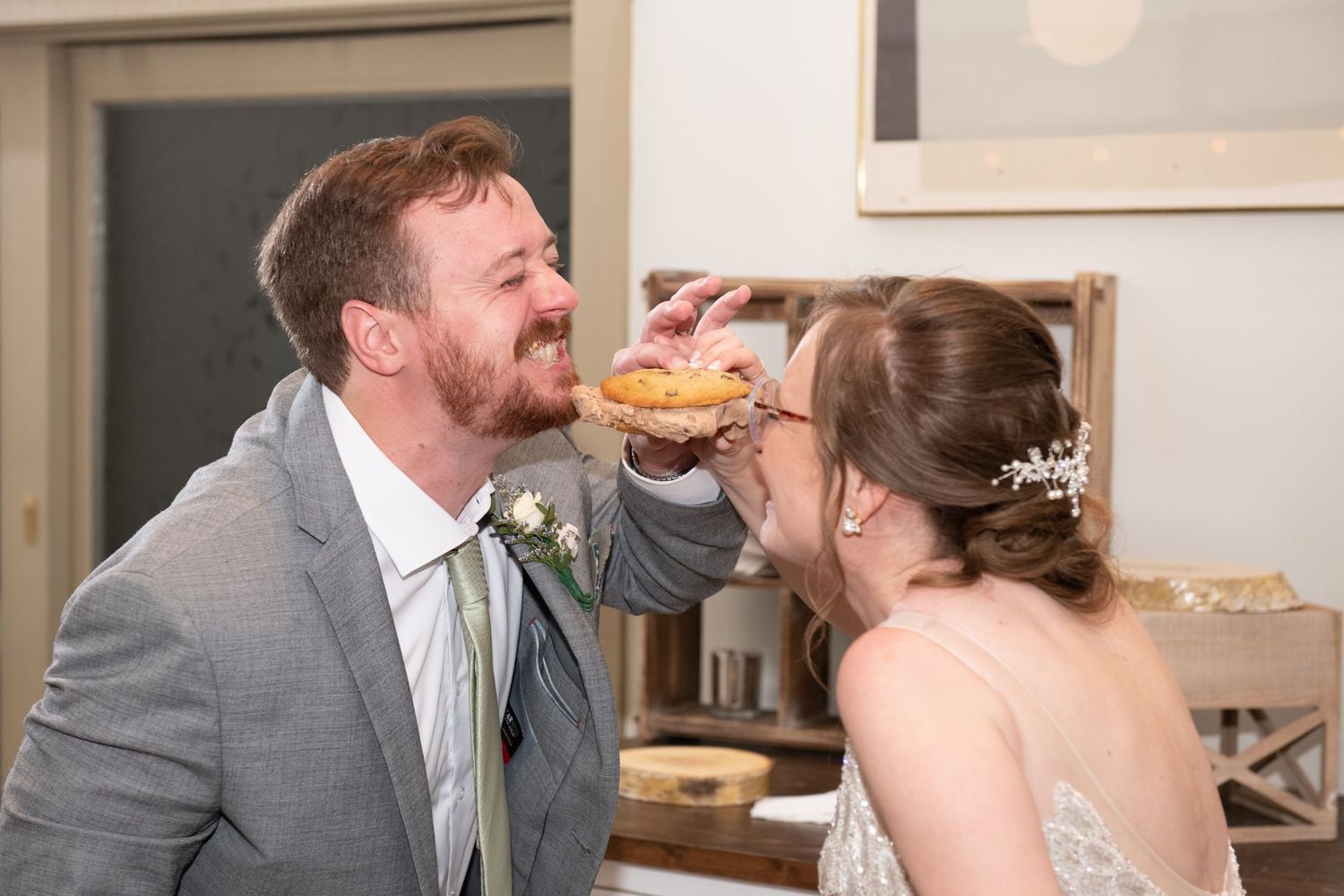 Newlyweds share a playful moment while eating at their wedding reception.