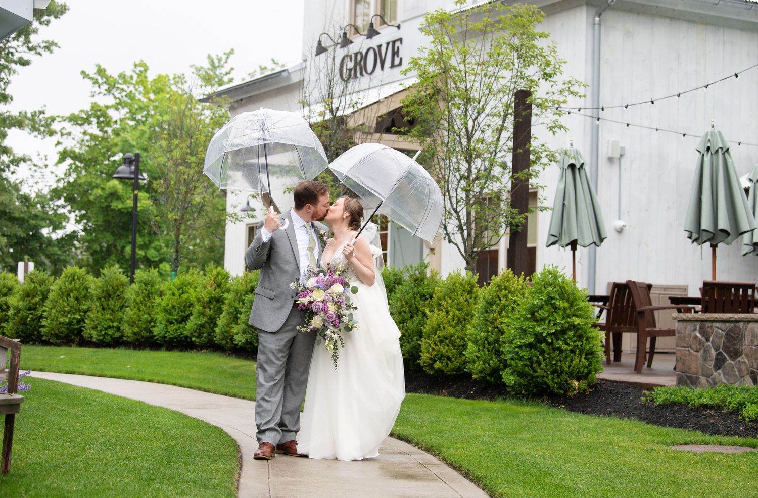 A couple shares a romantic moment in front of a white church building during their wedding ceremony.
