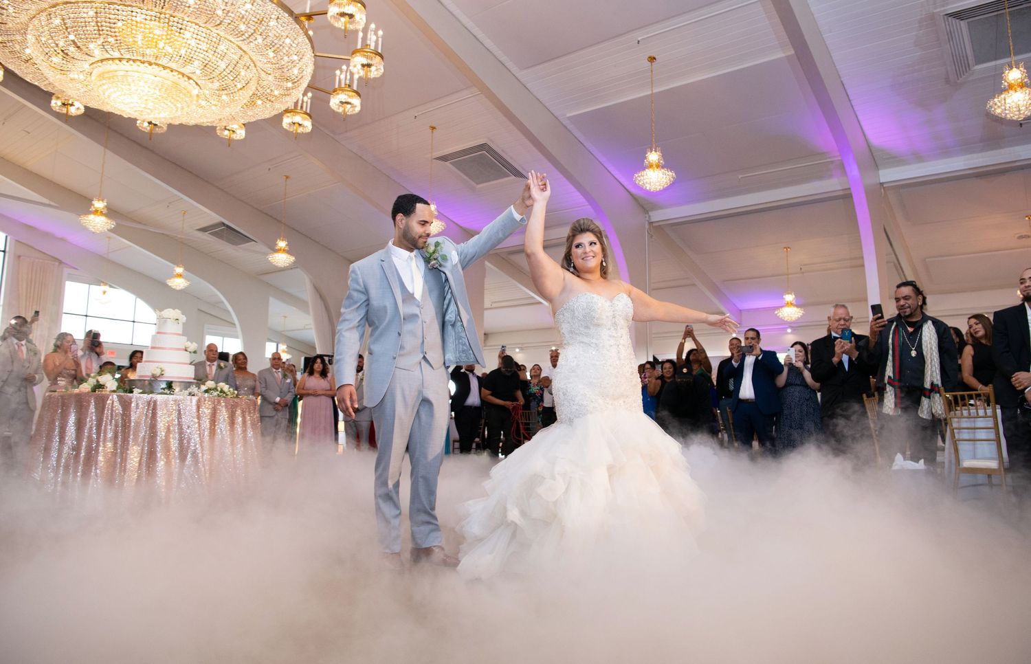 Wedding reception dance floor with purple uplighting and chandelier in elegant white ballroom. Danversport wedding