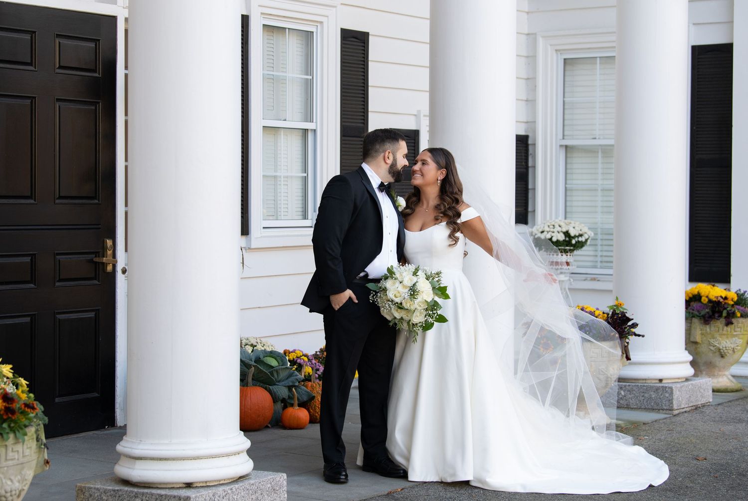 A series of wedding photos showing romantic moments between a couple against a white columned building exterior.