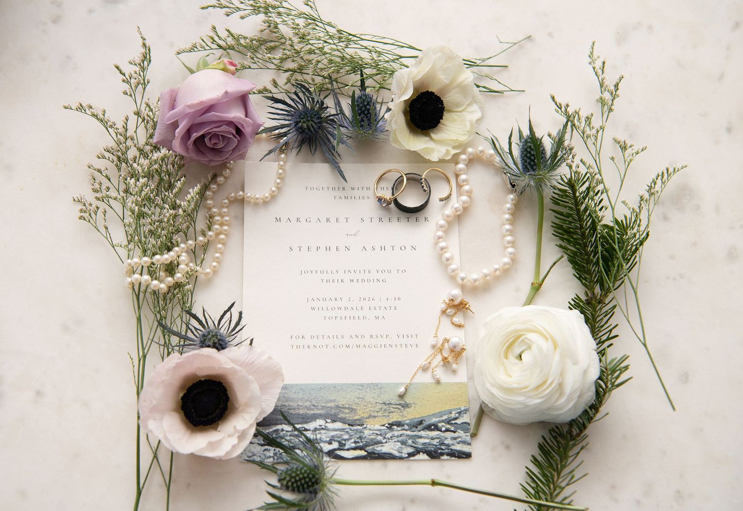Delicate floral arrangement with anemones, roses, and greenery displayed alongside vintage paper and ribbons.