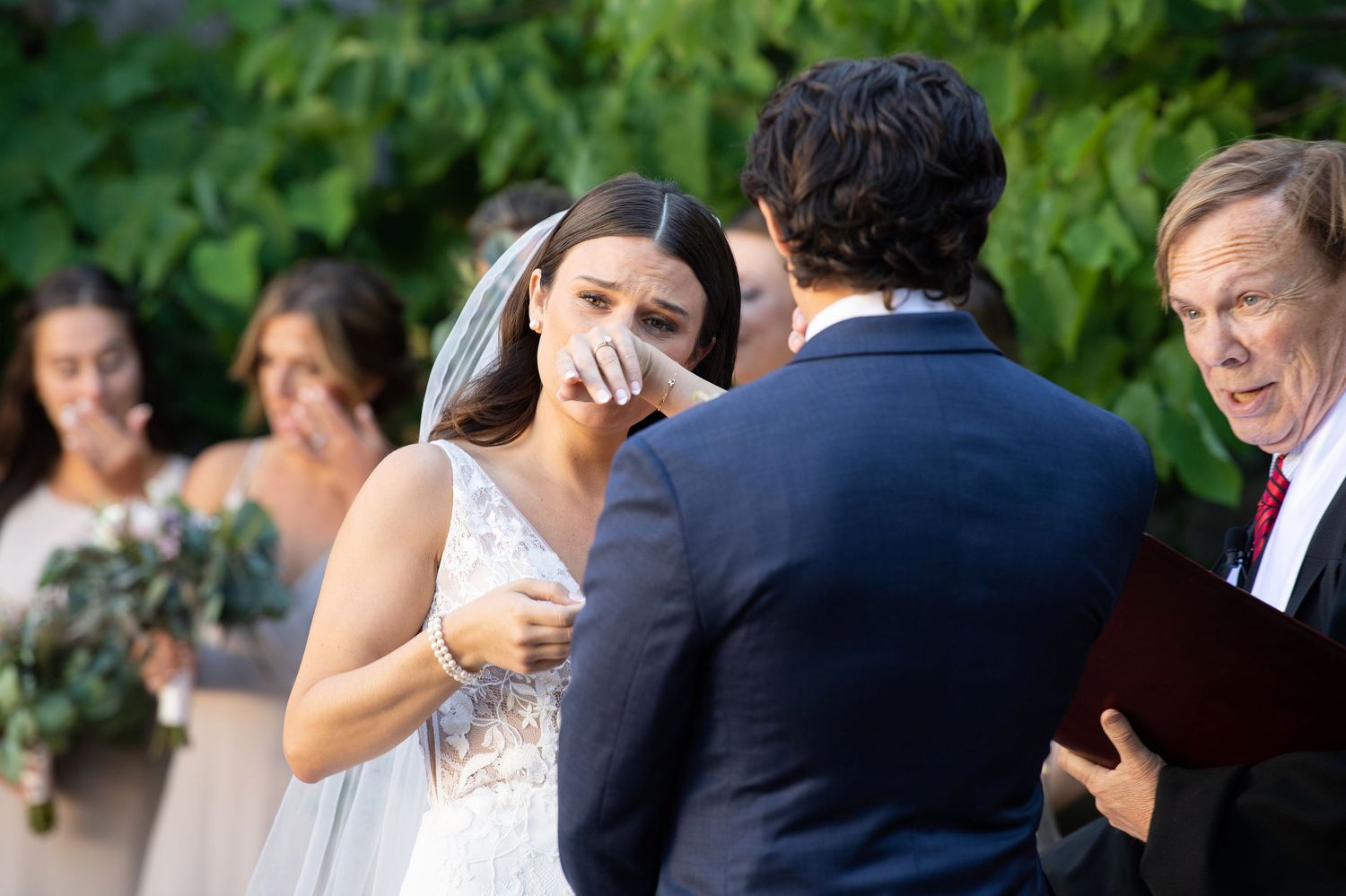 A joyful outdoor wedding ceremony captured during an emotional exchange of vows in a garden setting.