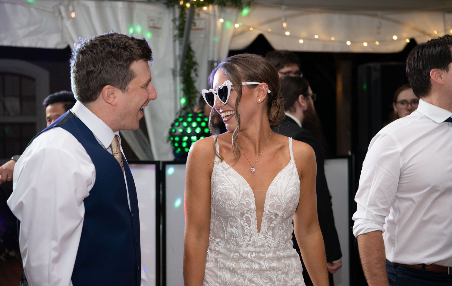 Wedding reception dance floor with string lights and festive atmosphere.