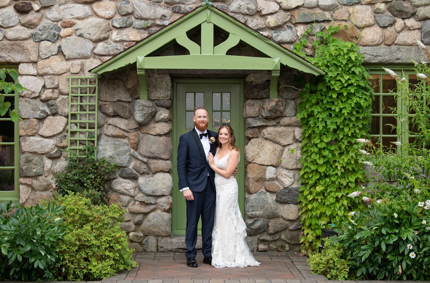 Rustic stone venue with green architectural details and climbing vines.