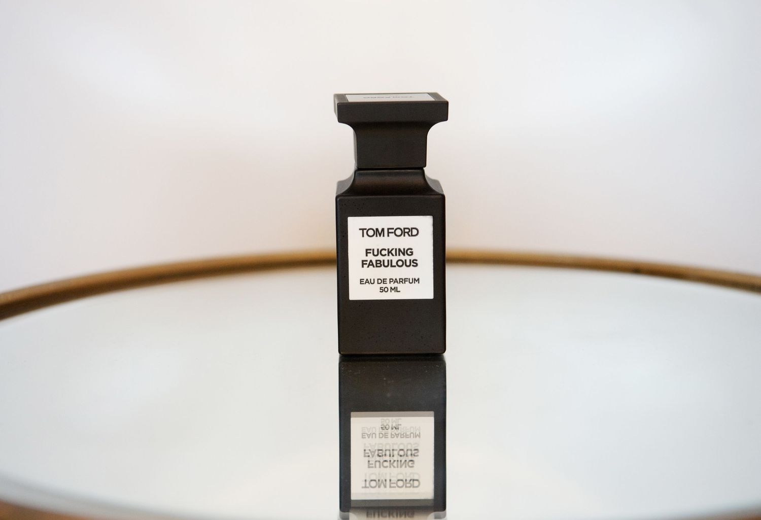 Luxury fragrance bottles and perfume containers arranged in a minimalist composition against white background.