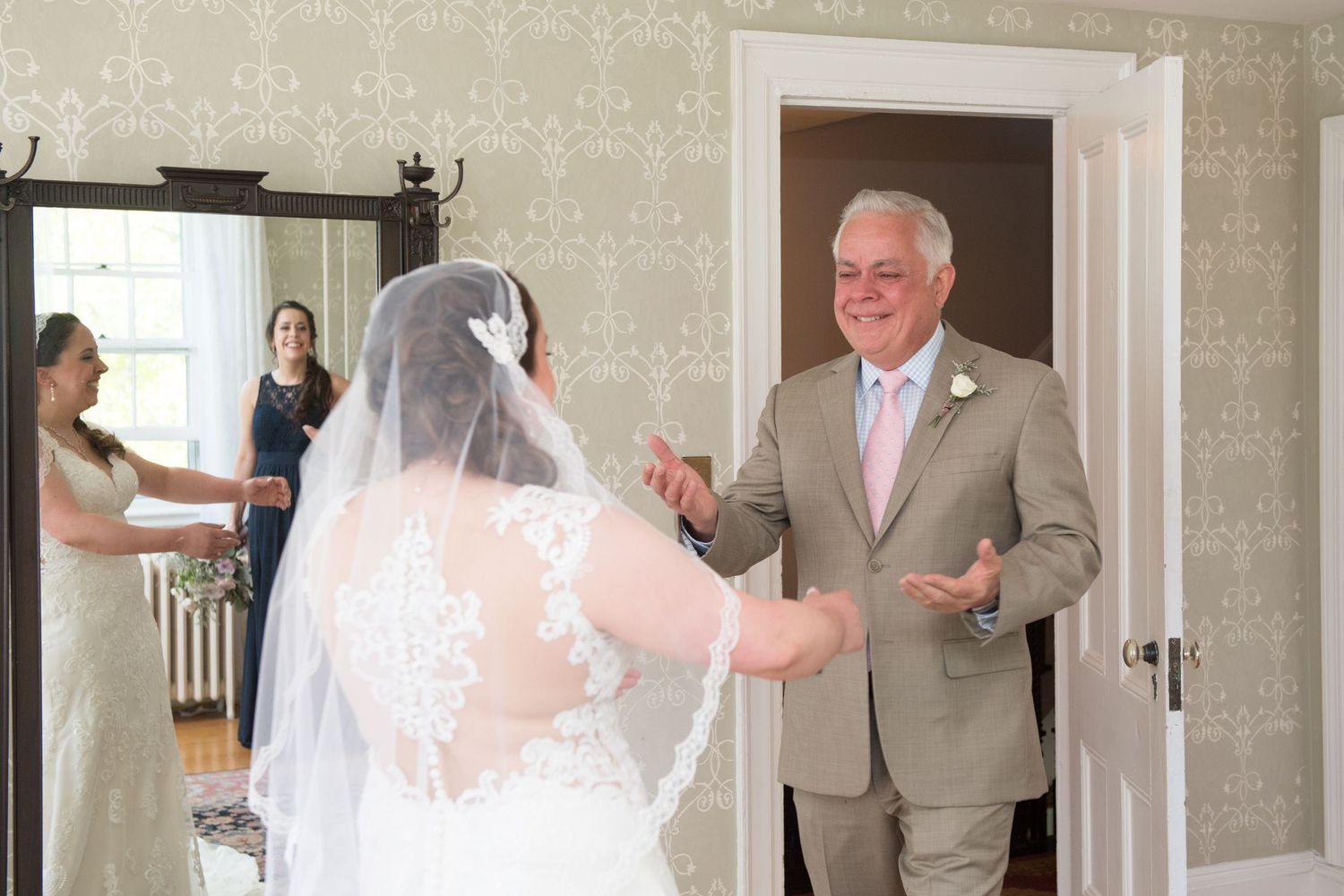 Emotional father of the bride sees his daughter in her wedding dress for the first time during a heartfelt first look moment.
