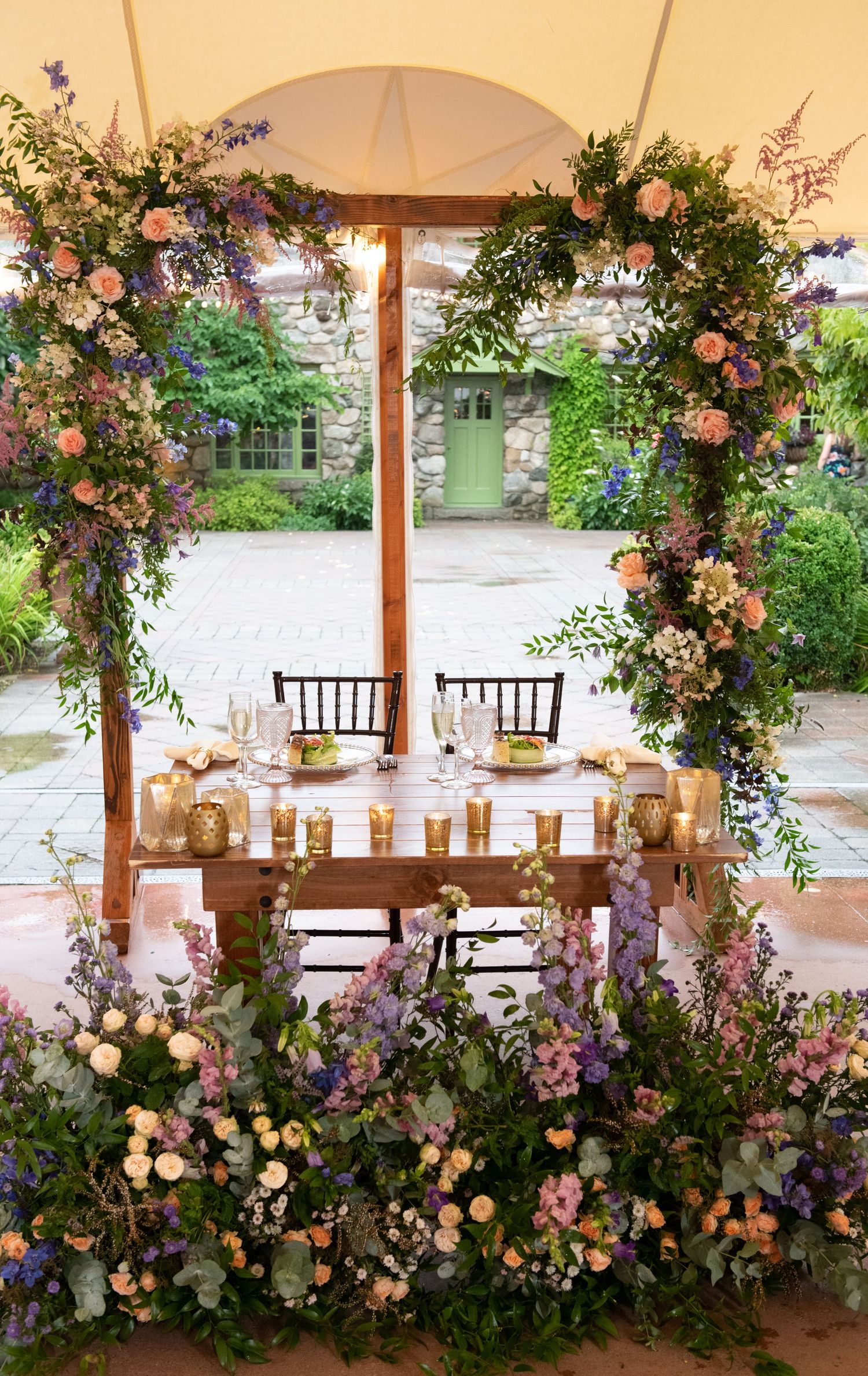 Reception tent decorated with cascading floral arrangements and romantic lighting.