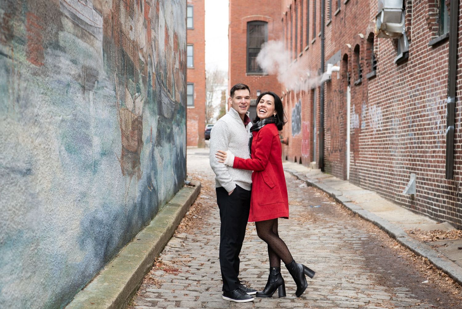 Two people pose together in a brick alley while smoke creates a dramatic atmosphere in multiple shots.