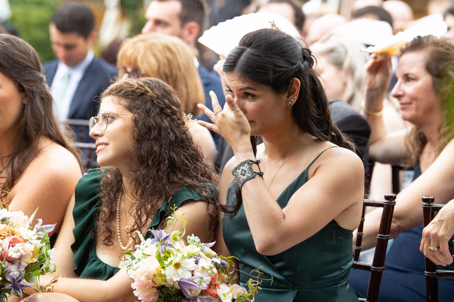 Wedding guests mingle and socialize during an outdoor reception on a sunny day.