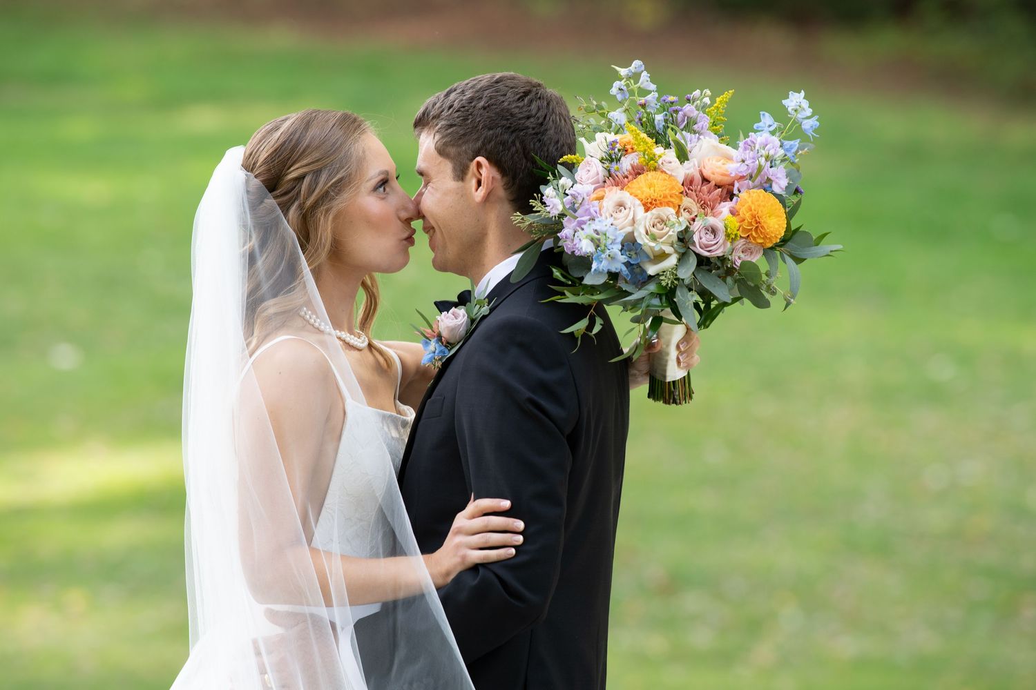 Romantic wedding portraits captured outdoors with lush greenery and natural lighting.