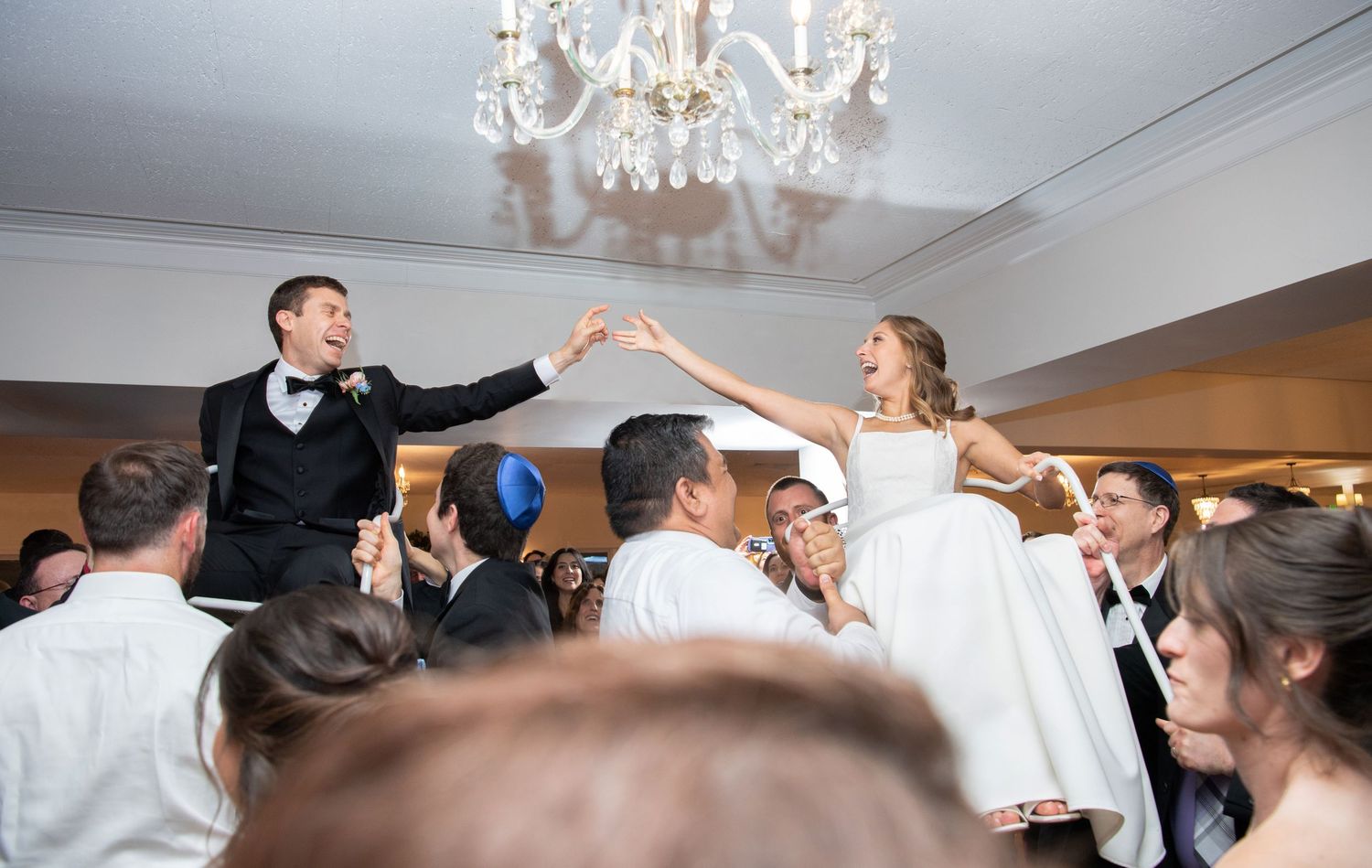 A wedding celebration montage showing dancing and joyful moments under elegant crystal chandeliers.