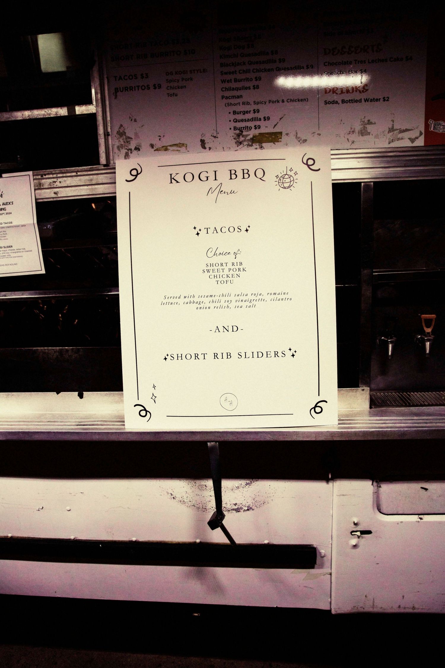 A series of dark restaurant menu signs mounted on a wall with text visible but partially obscured in low lighting.