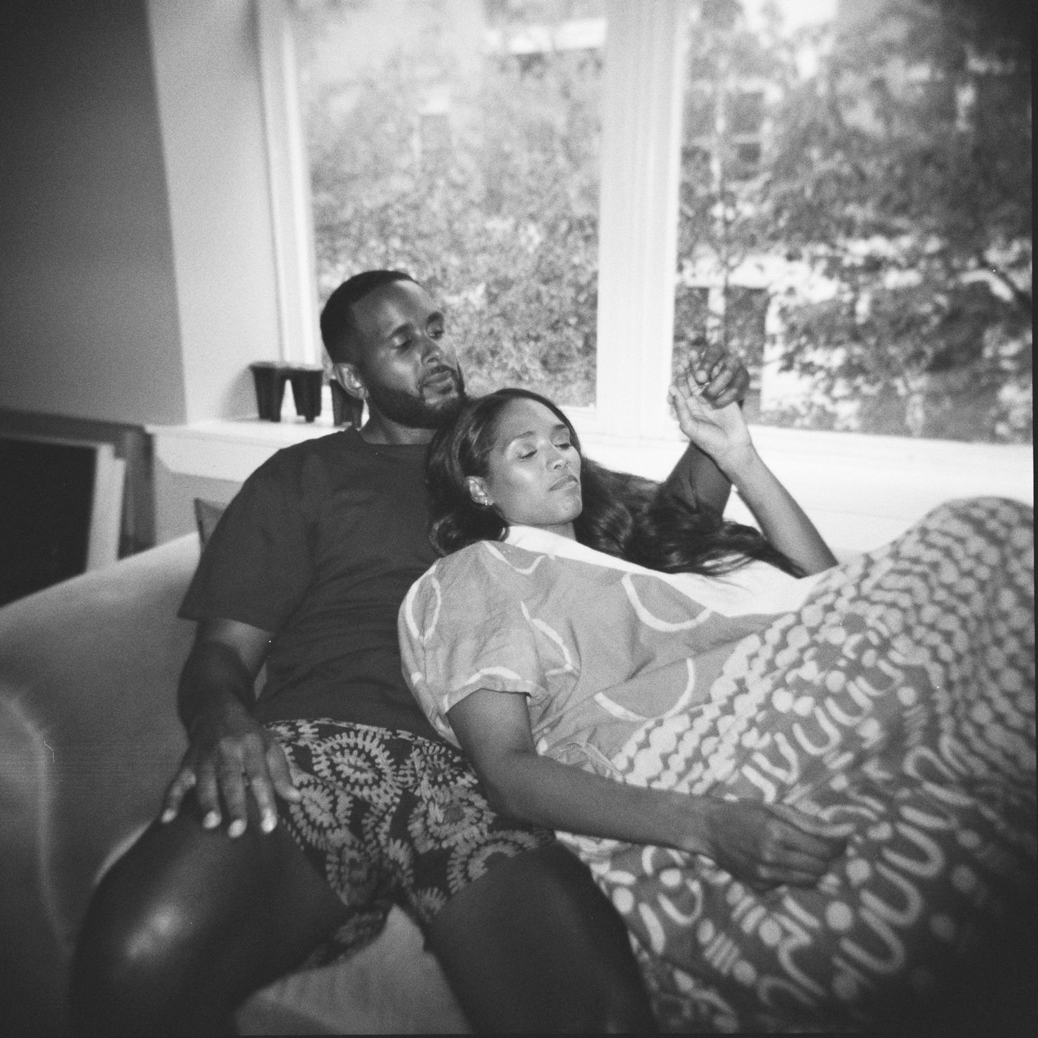 A black and white photo series showing people resting on a couch in various relaxed poses.