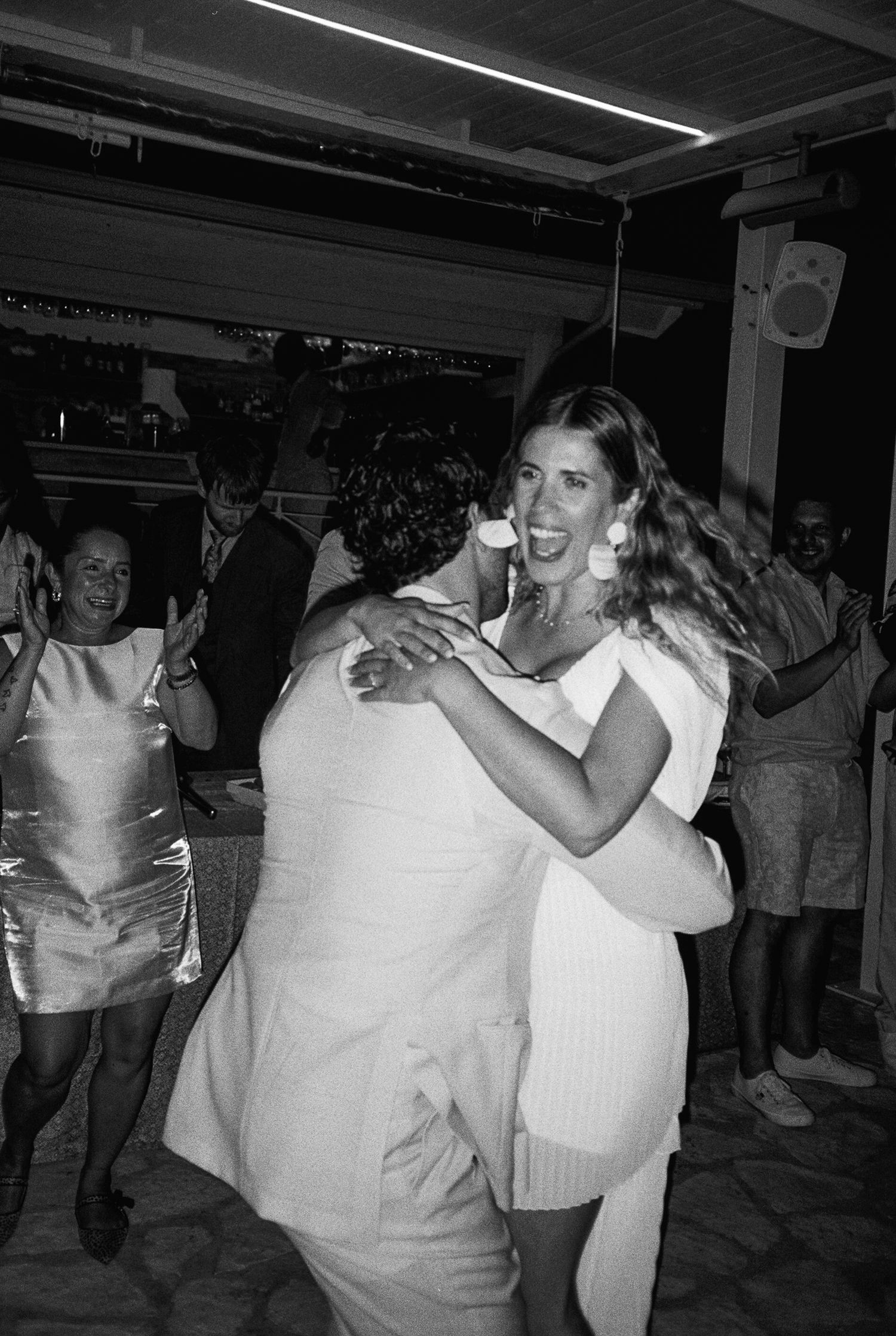 A black and white photo showing people dancing and enjoying themselves at what appears to be a party or social gathering.