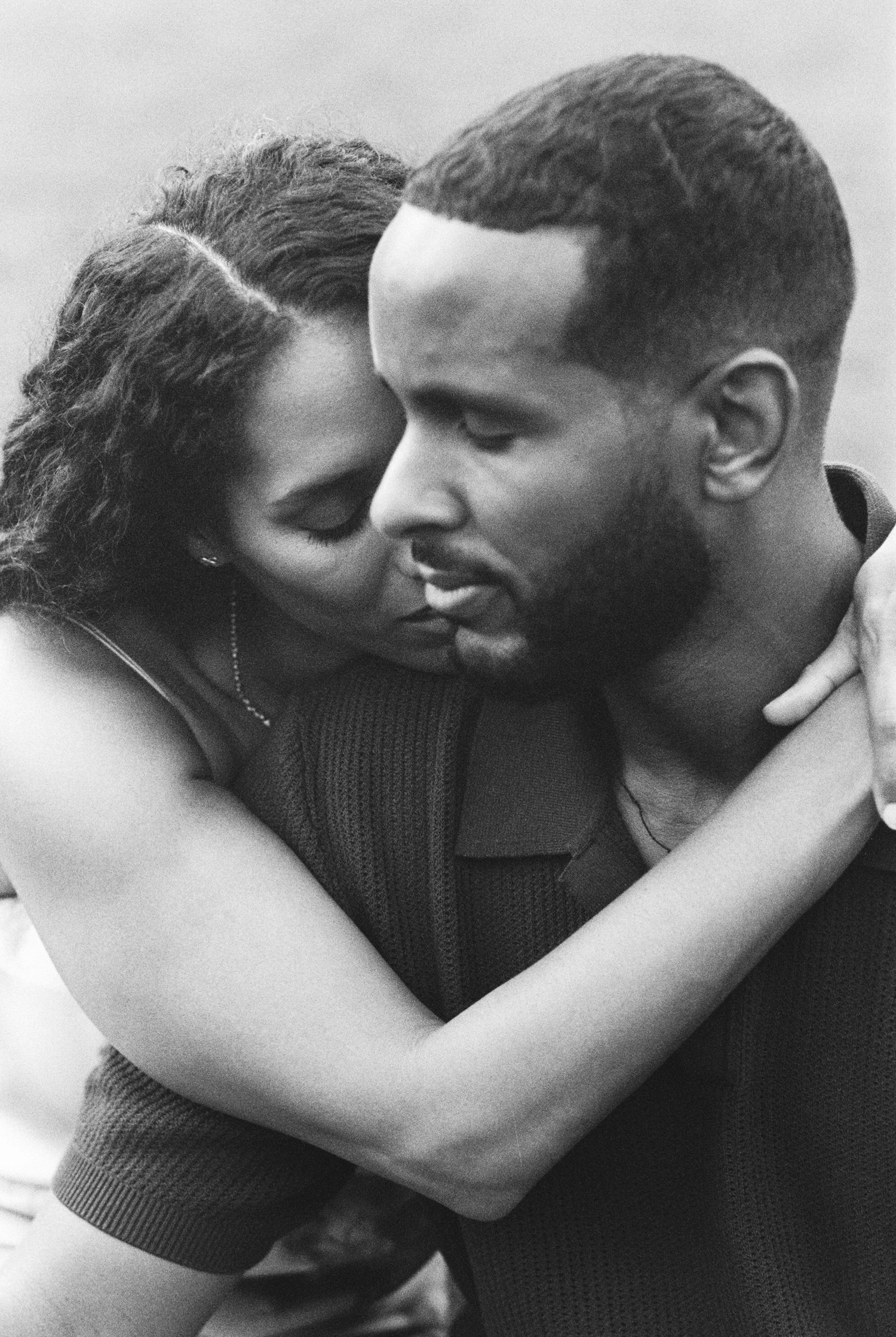 A romantic black and white photo sequence showing a couple embracing and kissing in four progressive frames.