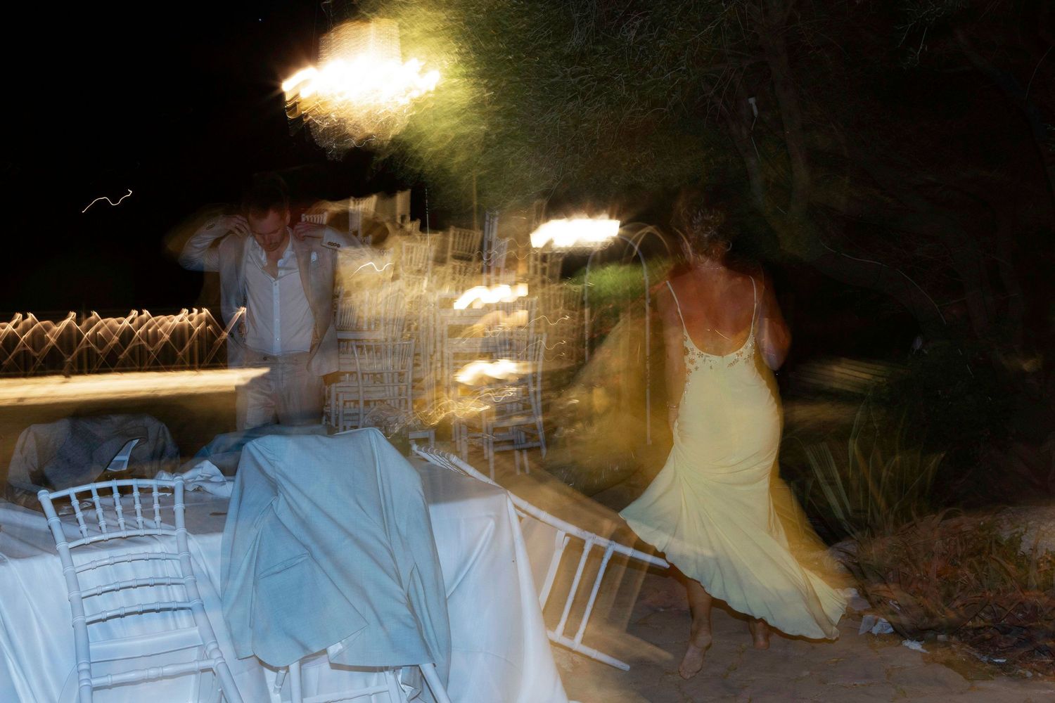 A series of dark and blurry nighttime photographs showing white chairs and dim lighting at an outdoor event.