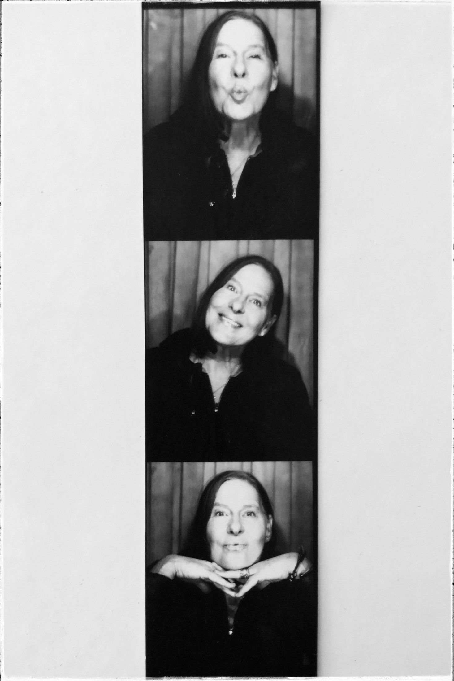 Black and white photo booth strip showing playful expressions and poses in vintage style portrait photography.