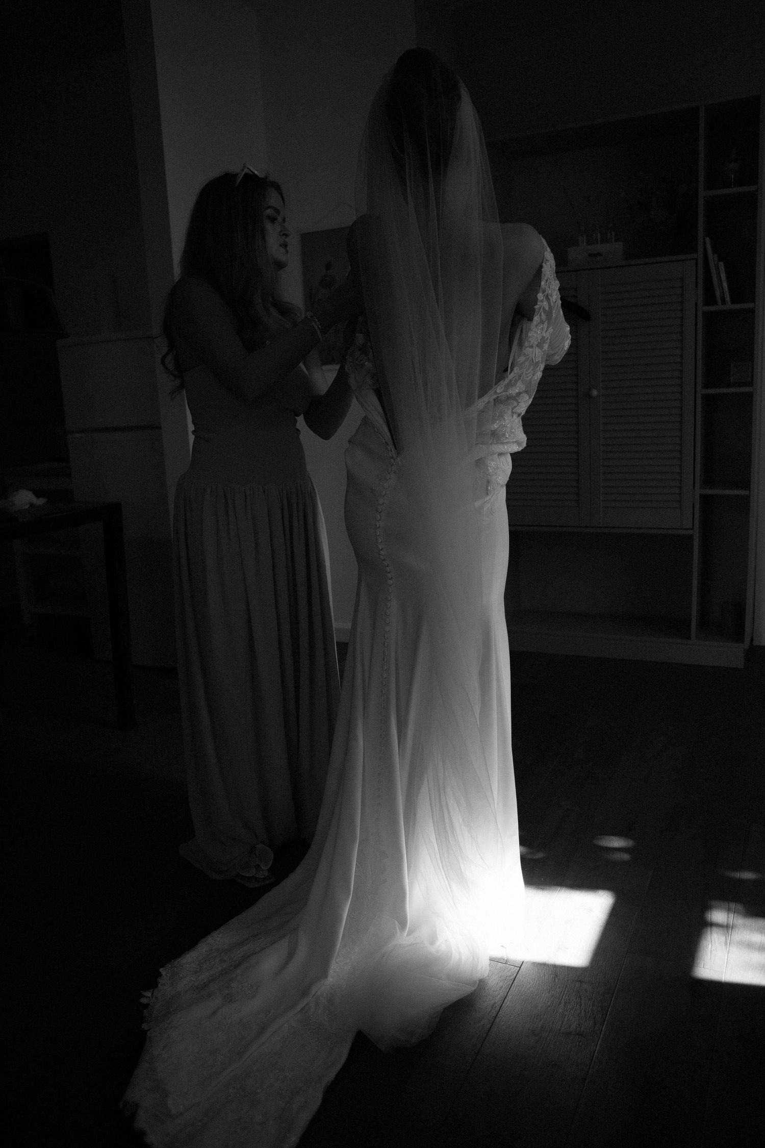 A ghostly figure in white dress moves through a dark room creating an ethereal glowing effect in this artistic series.