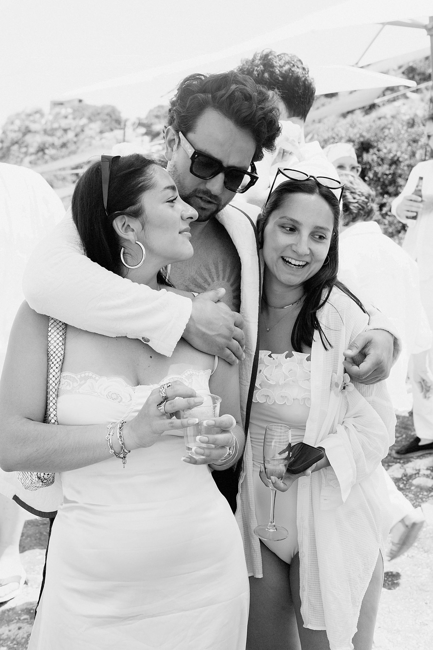 A sequence of romantic black and white photos showing a couple embracing and laughing together on a sunny day outdoors.