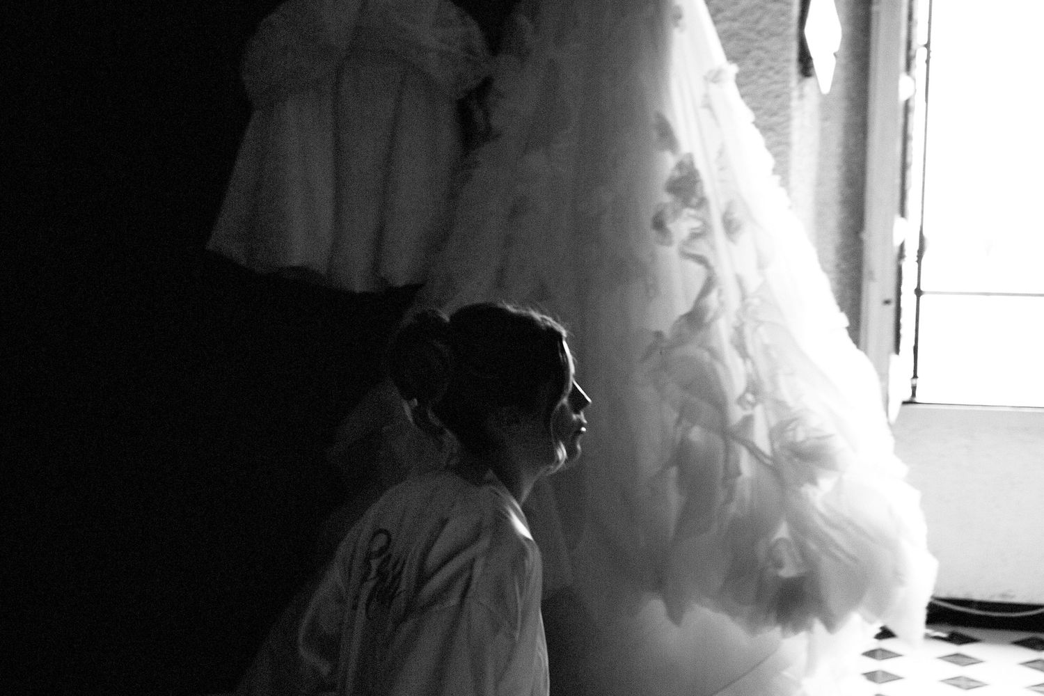 Silhouettes of people preparing for a wedding ceremony in a dimly lit room.