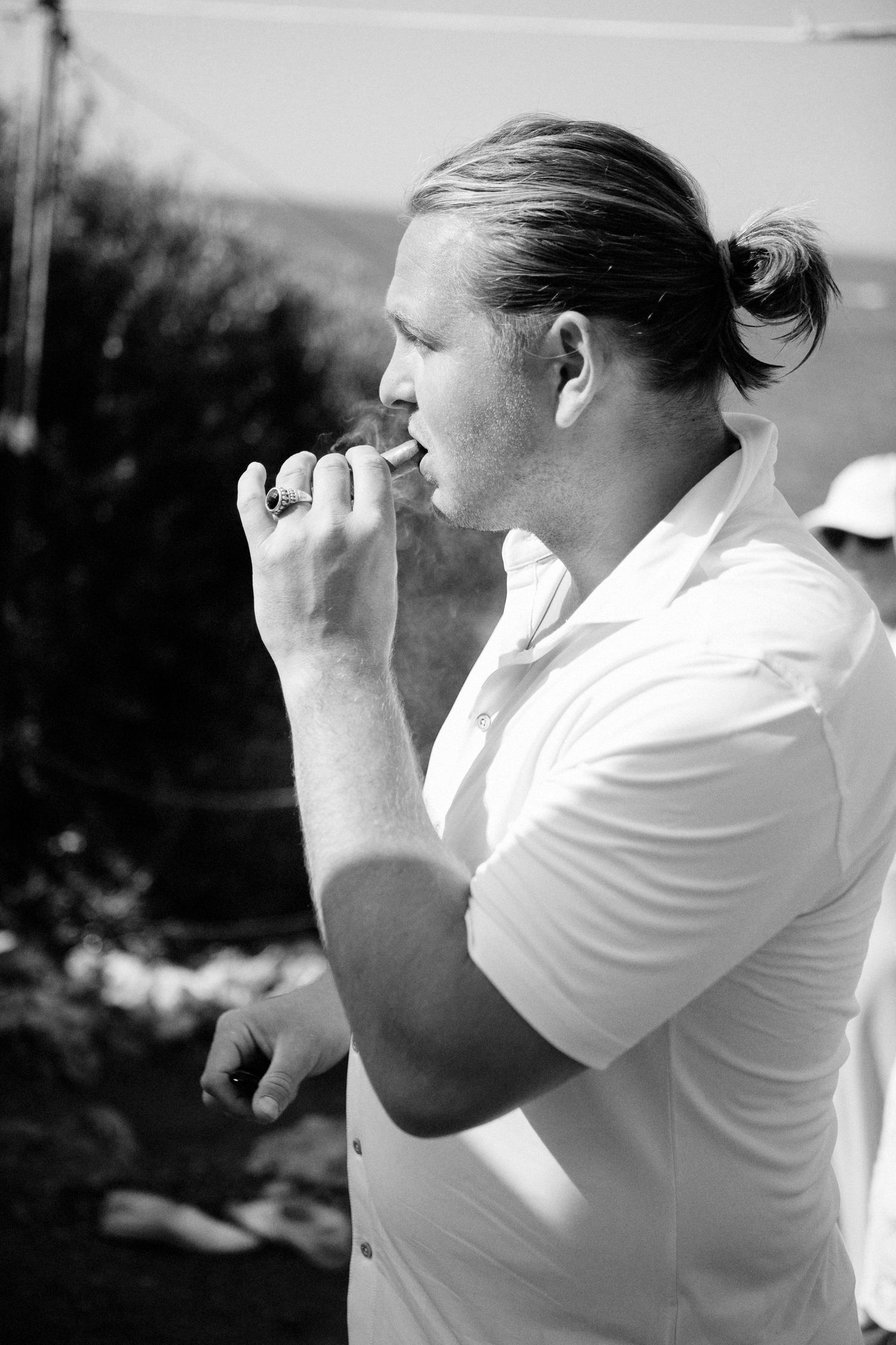 Black and white sequence showing person in white shirt looking through binoculars against blurred background.