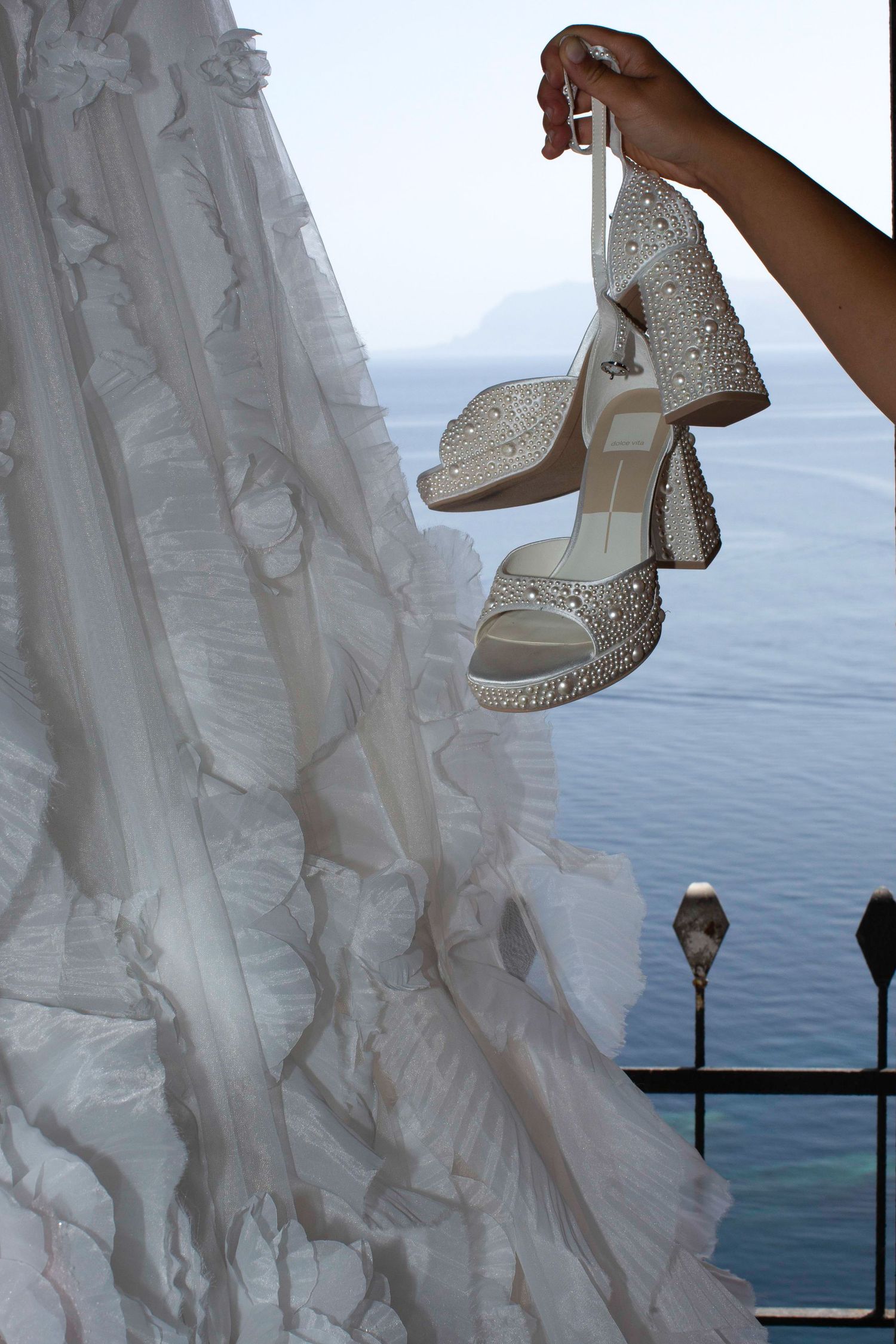 A series of photos showing white wedding dress details and sparkly bridal shoes against an ocean backdrop.