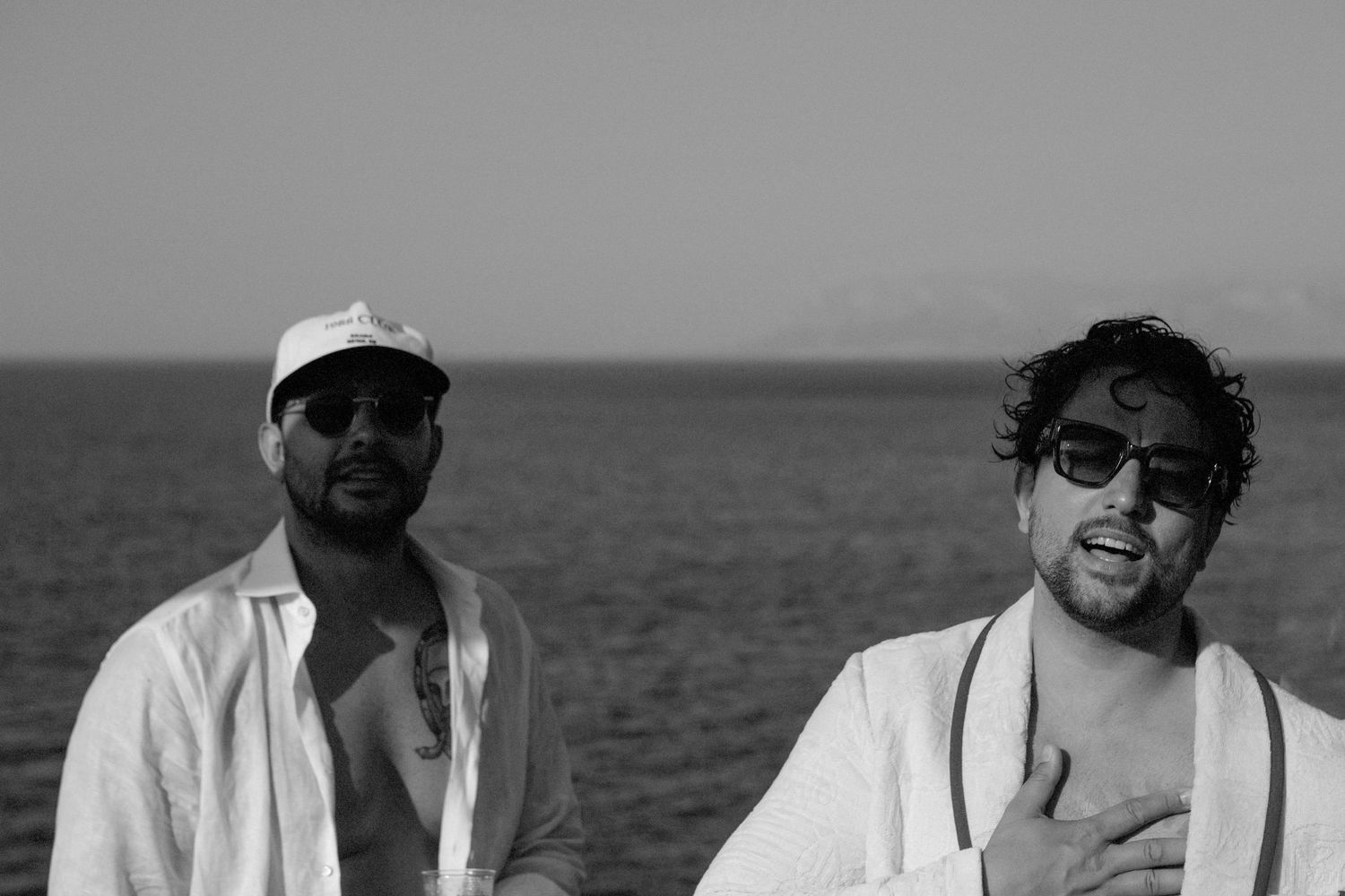 A series of black and white photos showing people enjoying time together on a boat in casual summer attire.