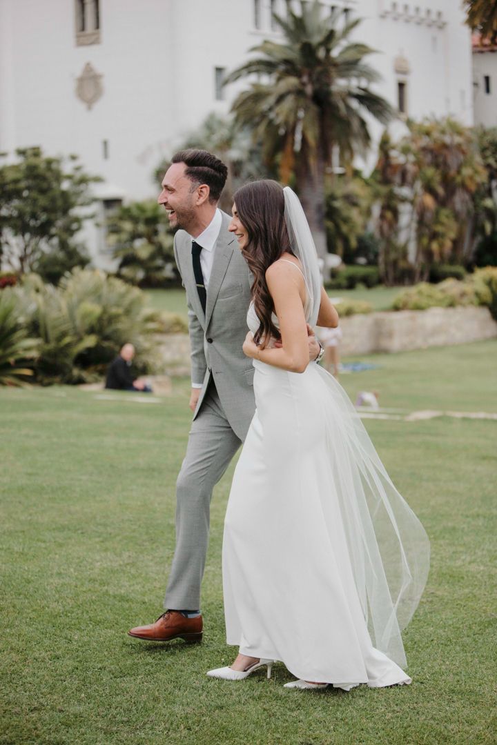 A series of candid wedding photos showing a couple dancing playfully on a manicured lawn near palm trees.