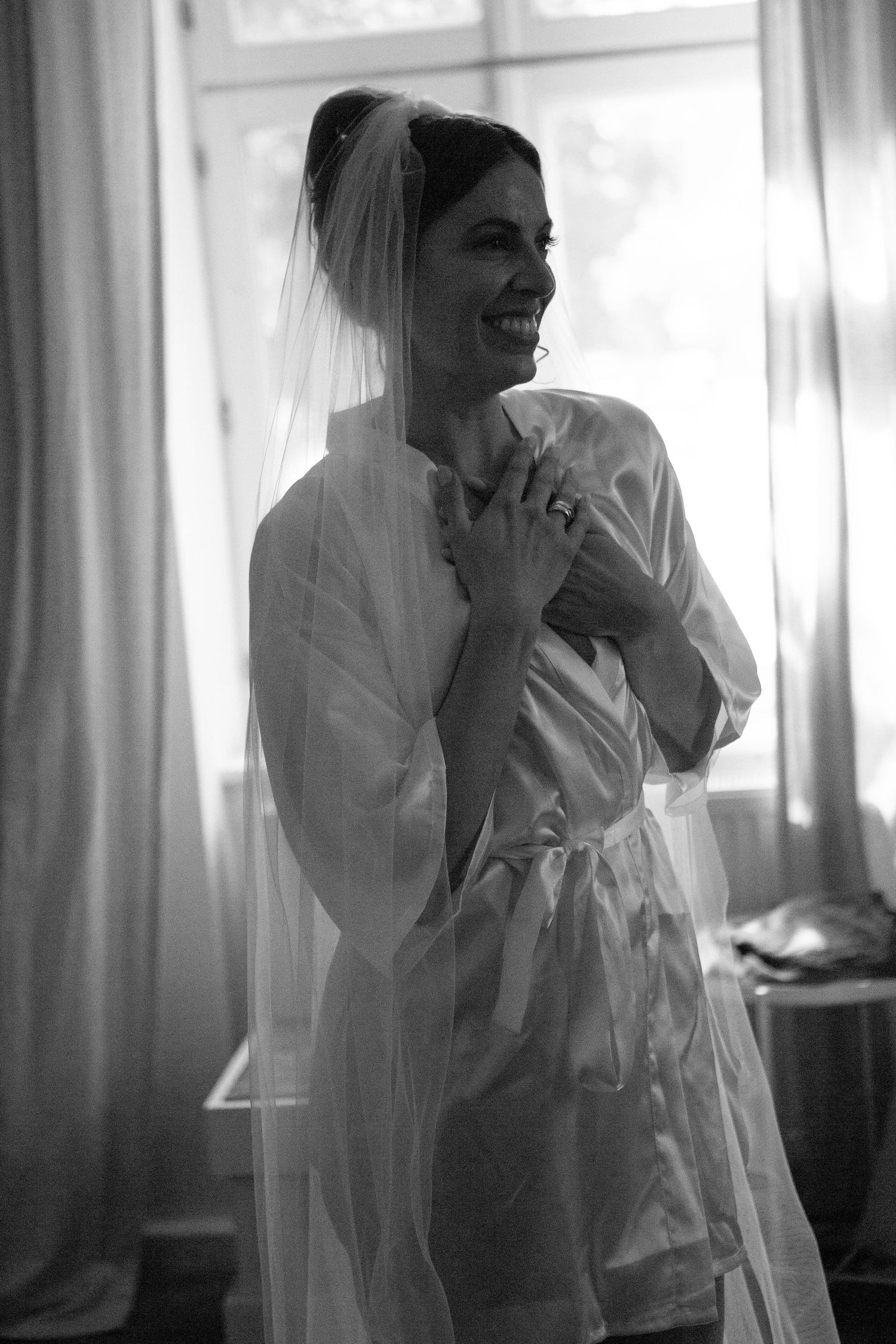 A black and white photo series showing a bride in a veil getting ready on her wedding morning.
