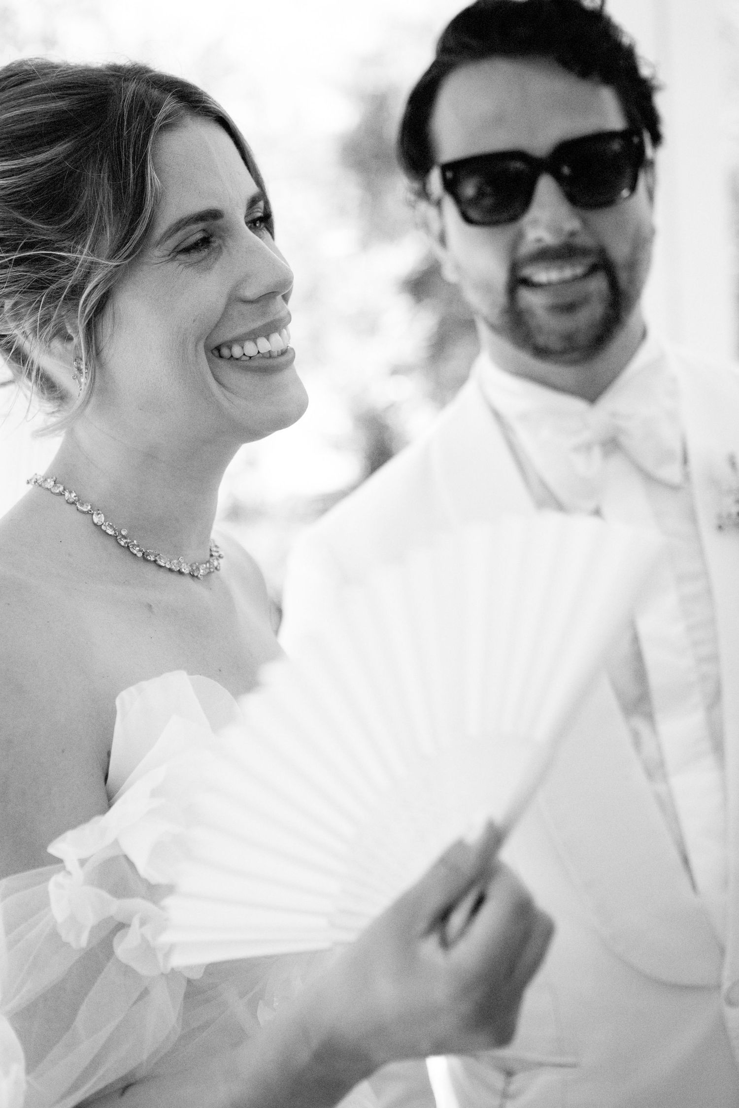 A series of black and white wedding photos showing joyful candid moments between a couple.