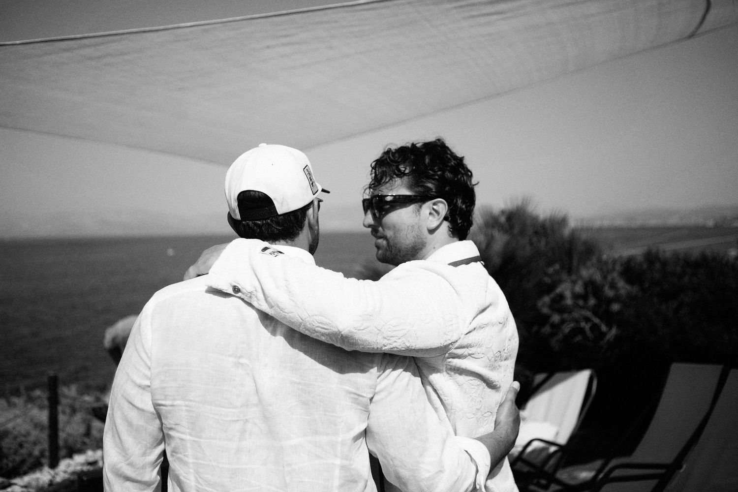 A series of black and white photographs showing a couple embracing against scenic outdoor backgrounds.