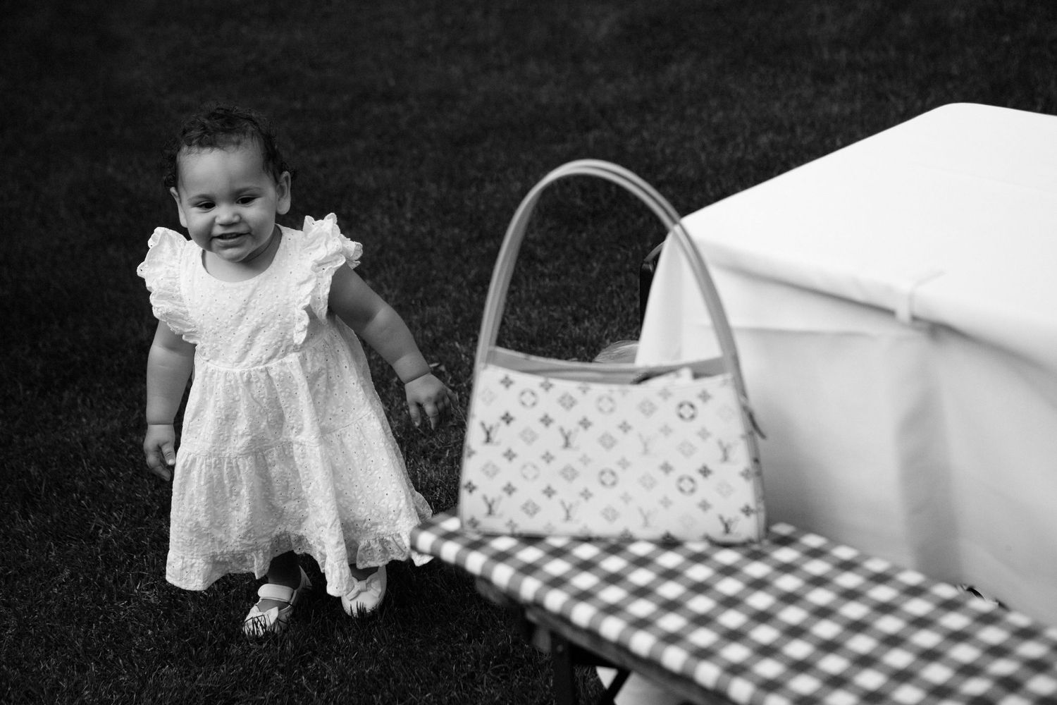 Vintage black and white photo series showing a baby crawling and playing on a checkered blanket.