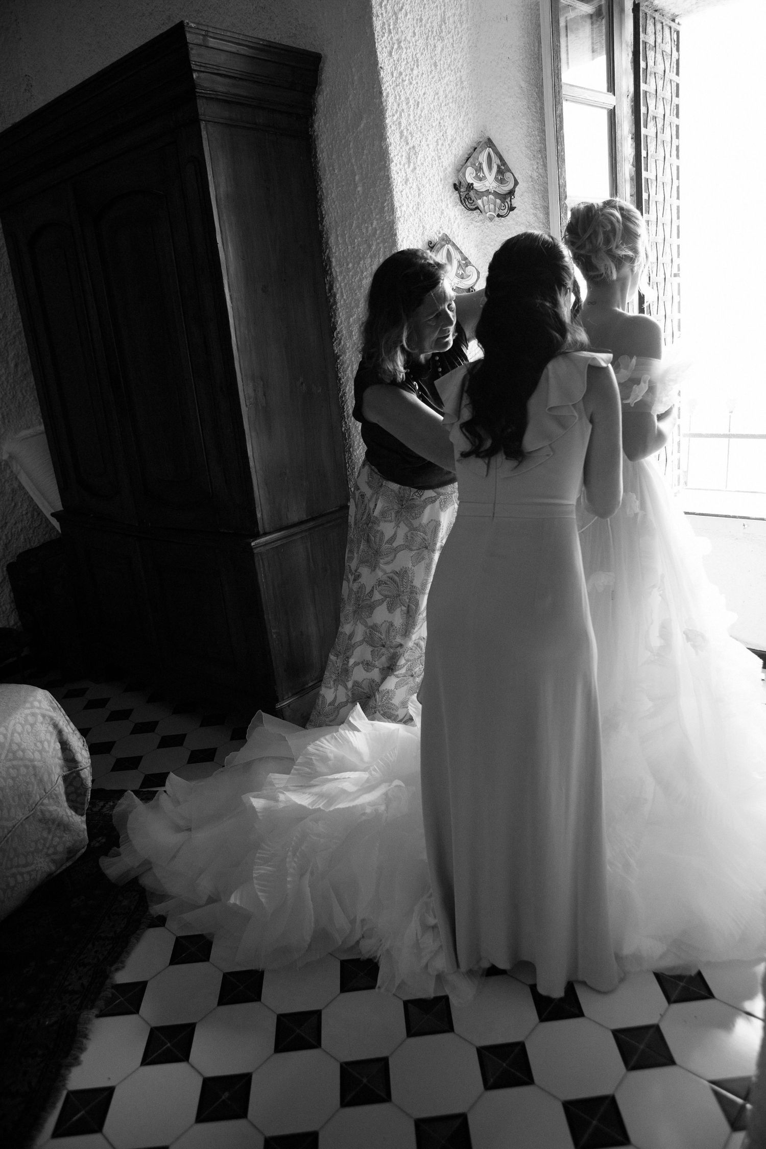 A sequence of black and white wedding preparation photos showing silhouettes against a bright window.