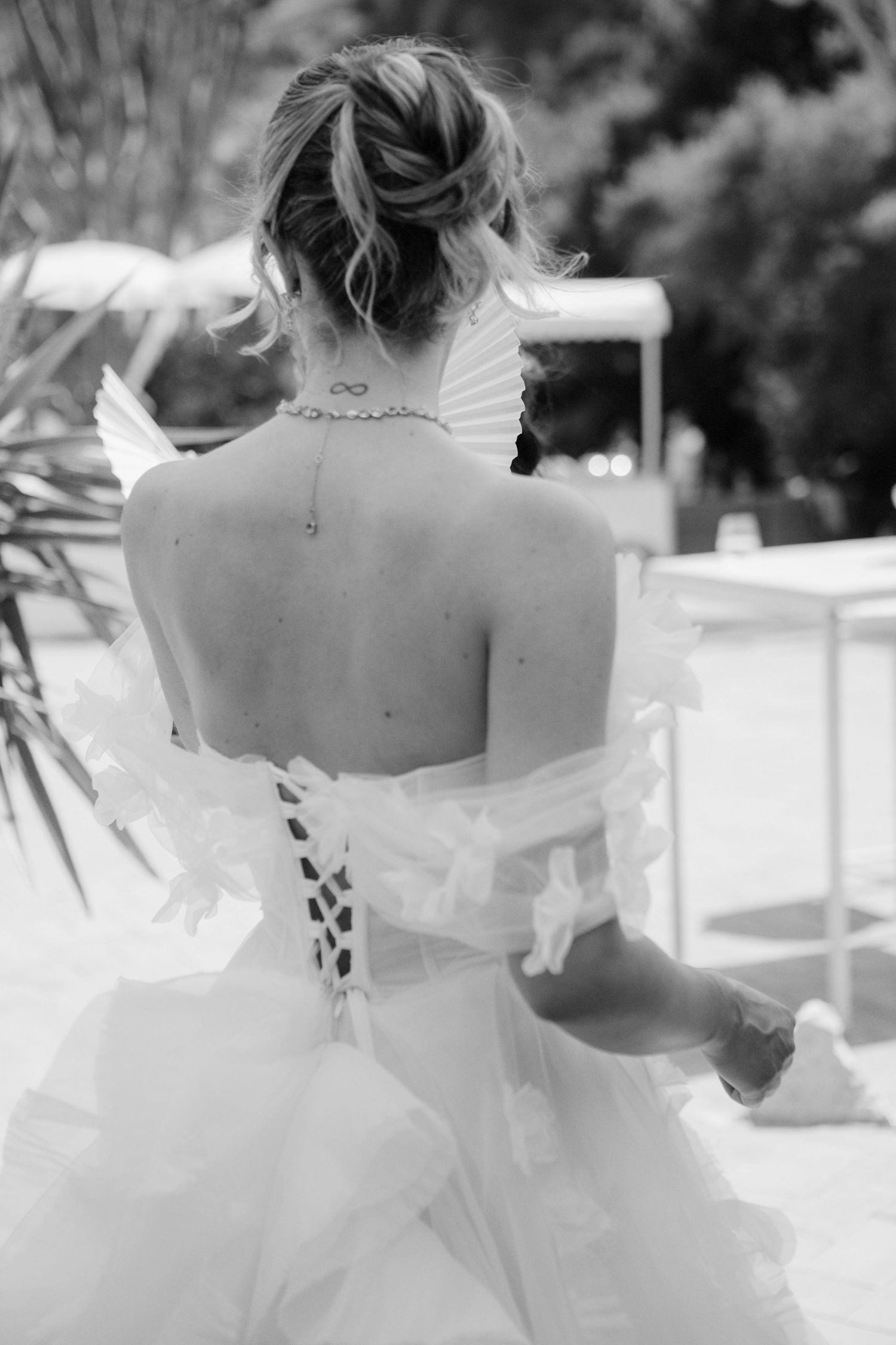 A black and white photo series showing a bride in a flowing white dress twirling and dancing outdoors.