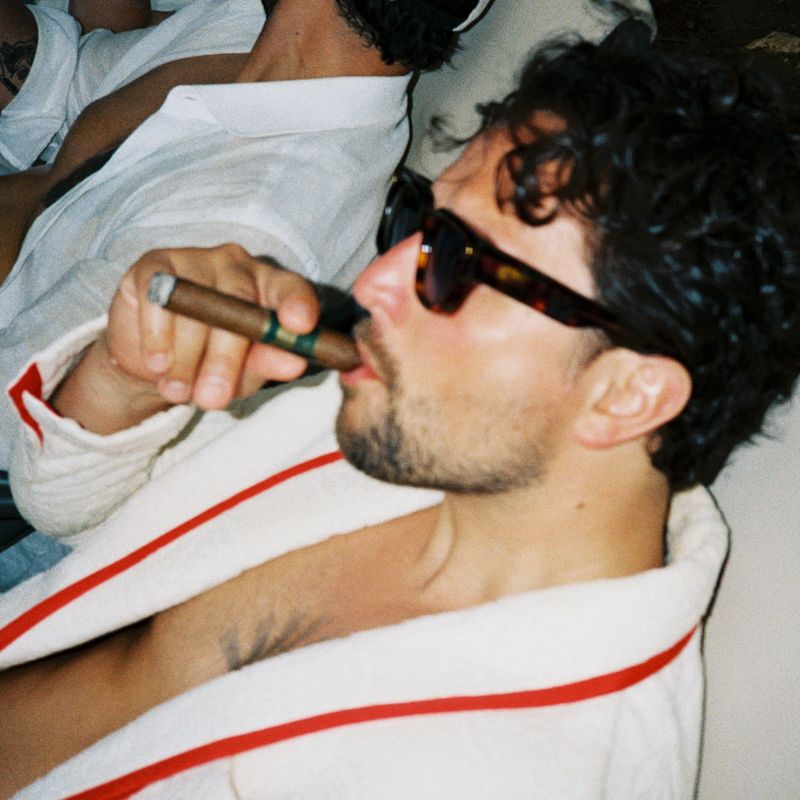 Person wearing white and red striped clothing resting on white bedding in a series of candid photos.